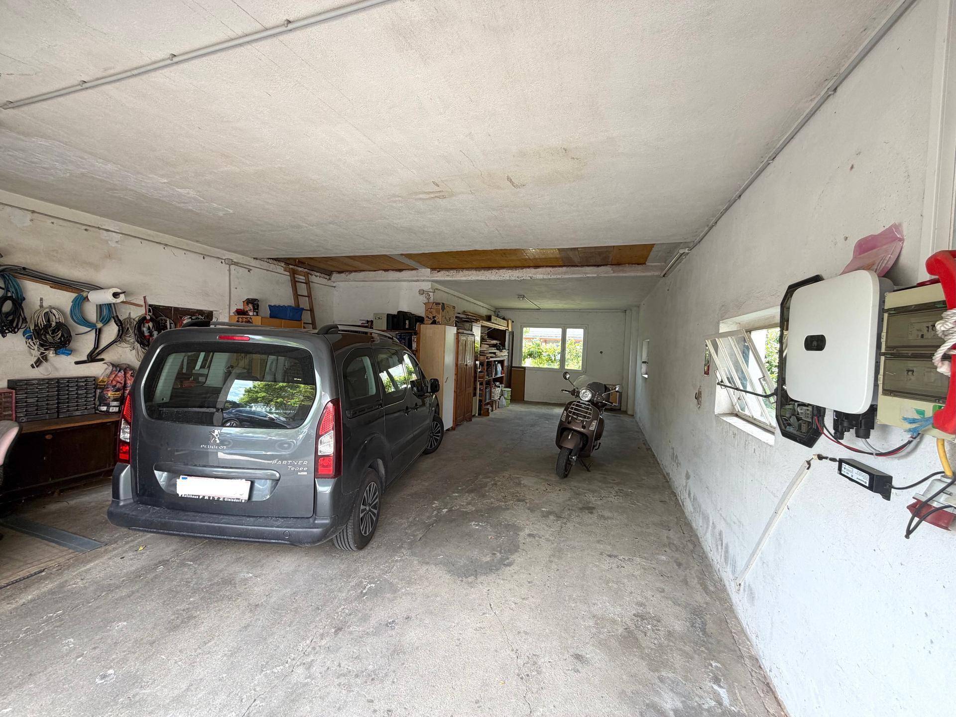 Geräumige Garage mit geparktem Auto und Stauraum.