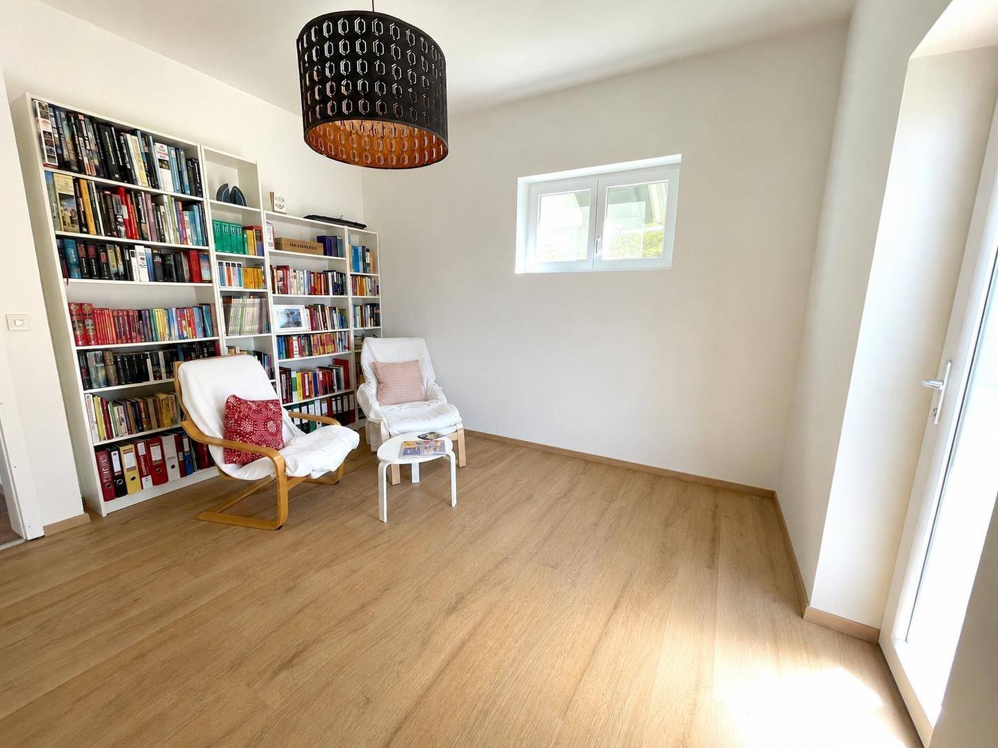Gemütlicher Raum mit Bücherregalen und Lesesesseln, ideal für ruhige Stunden und Entspannung.