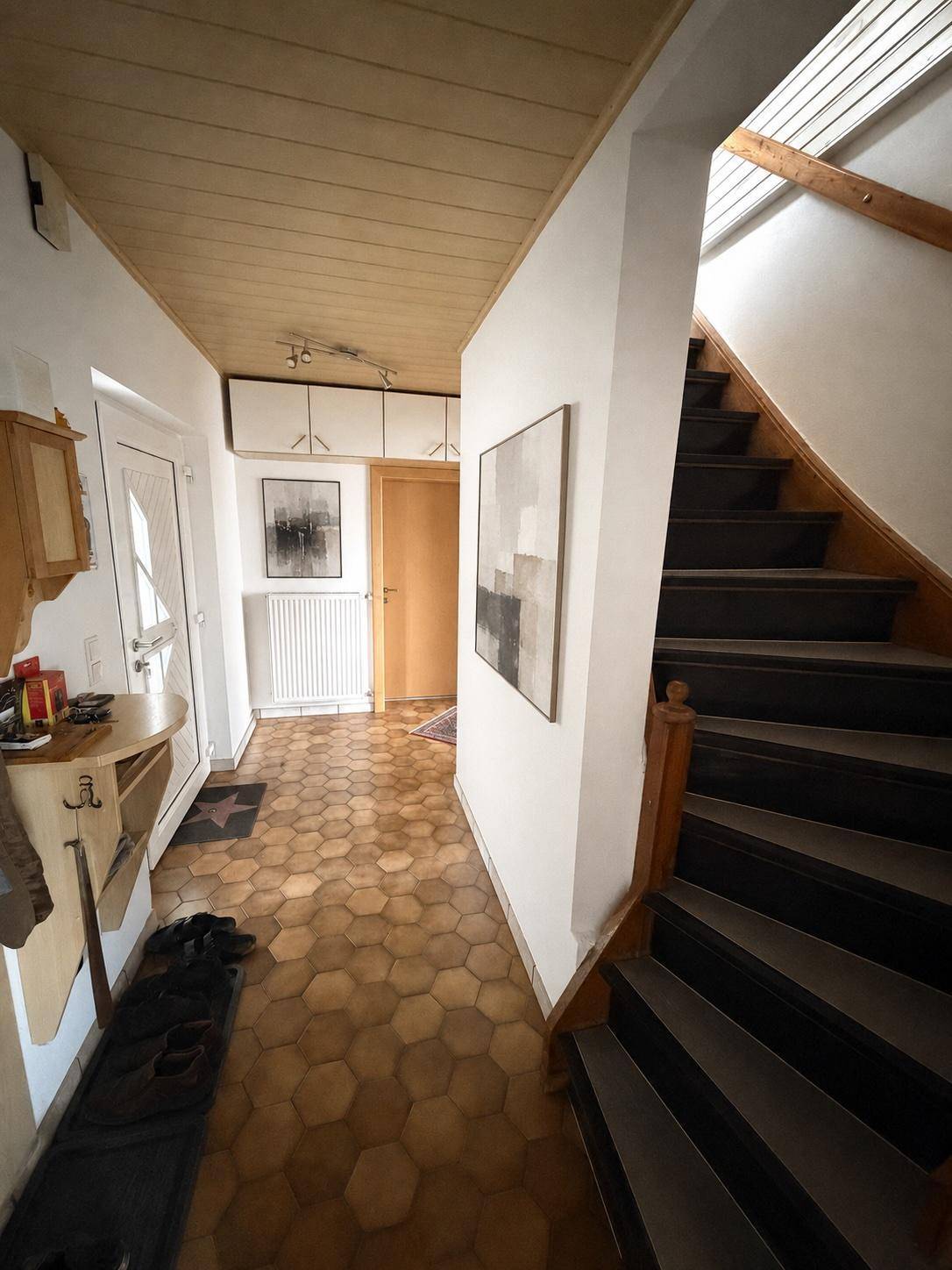 Eingangsbereich mit sechseckigen Fliesen und Treppe zum Obergeschoss.