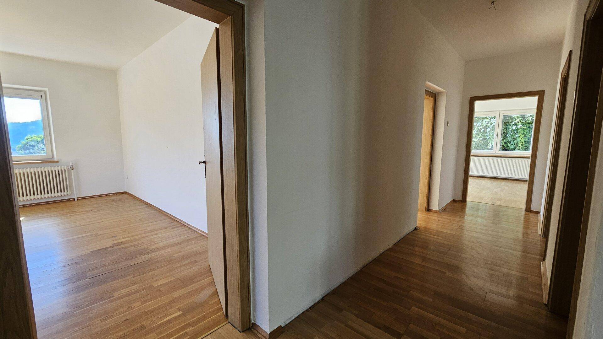 Geräumiger Flur mit Parkettboden und mehreren Holztüren, die zu den angrenzenden Zimmern führen.