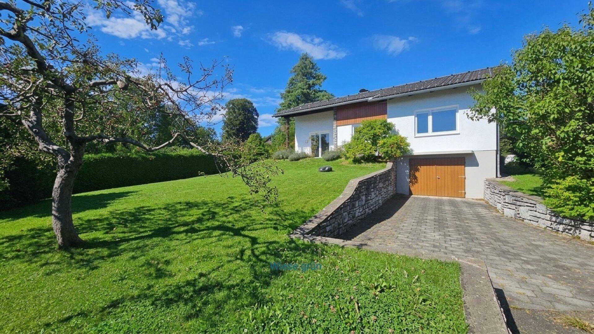 Einfamilienhaus mit Zufahrt, Garage und großem Garten mit altem Baumbestand.