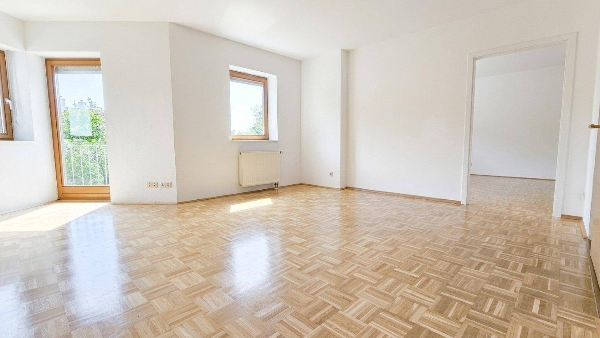 Lichtdurchfluteter Raum mit Parkettboden und weißen Wänden, bereit zur individuellen Gestaltung.