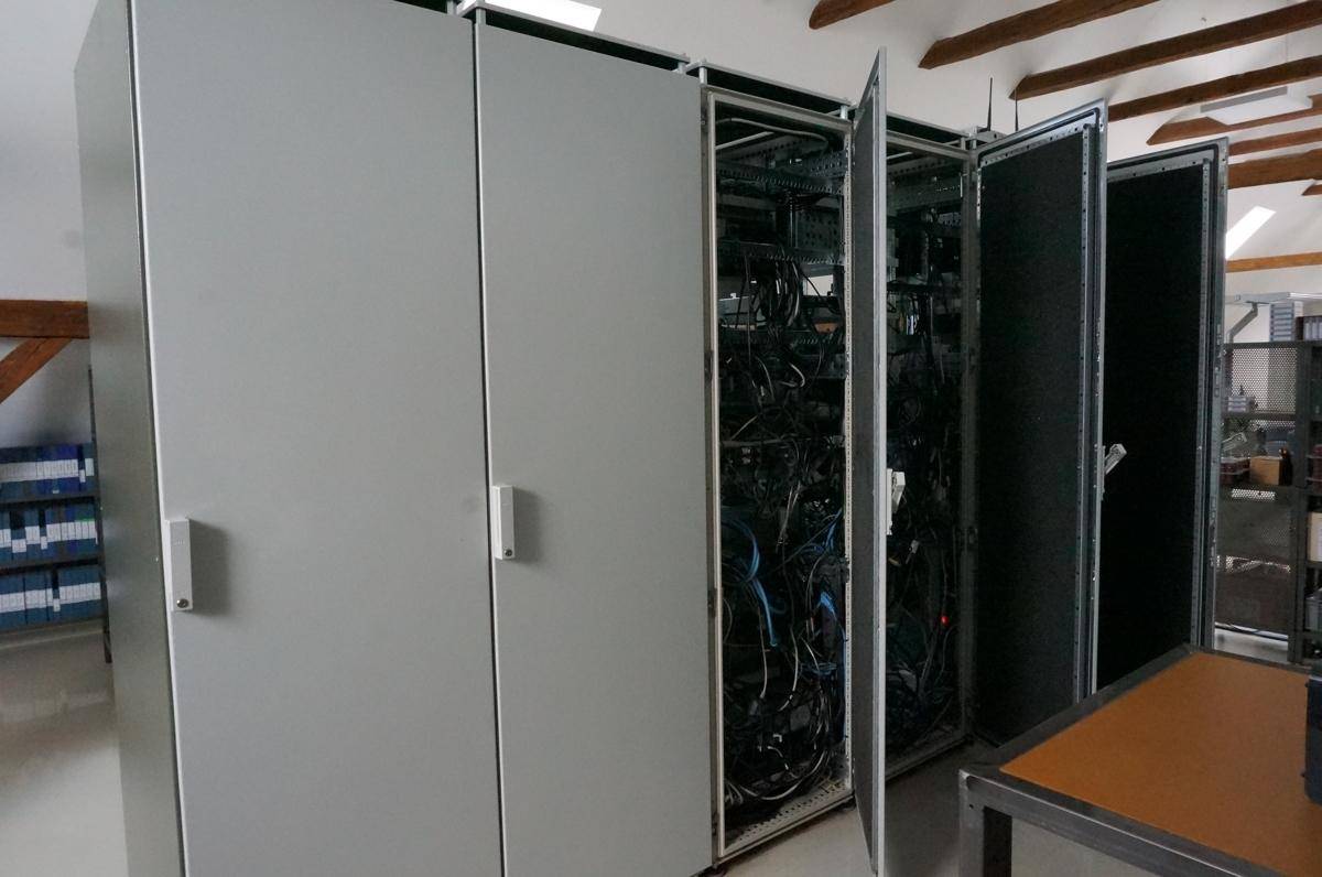 Nahaufnahme von Serverracks mit geöffneten Türen, die die Verkabelung und Technik zeigen.