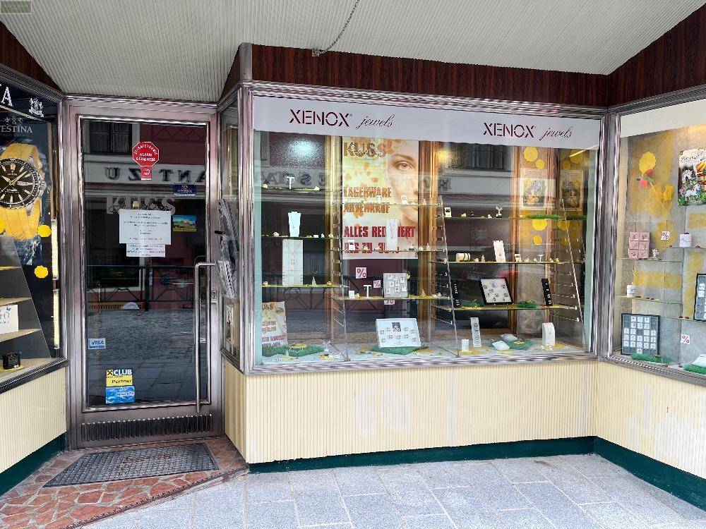 Schaufenster eines Juweliergeschäfts mit Auslagen und einem Eingangsbereich in einem historischen Gebäude.