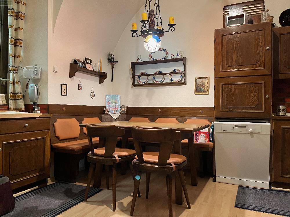 Gemütliche Essküche mit Holztisch, Eckbank und traditionellen Holzschränken, perfekt für Familienessen.