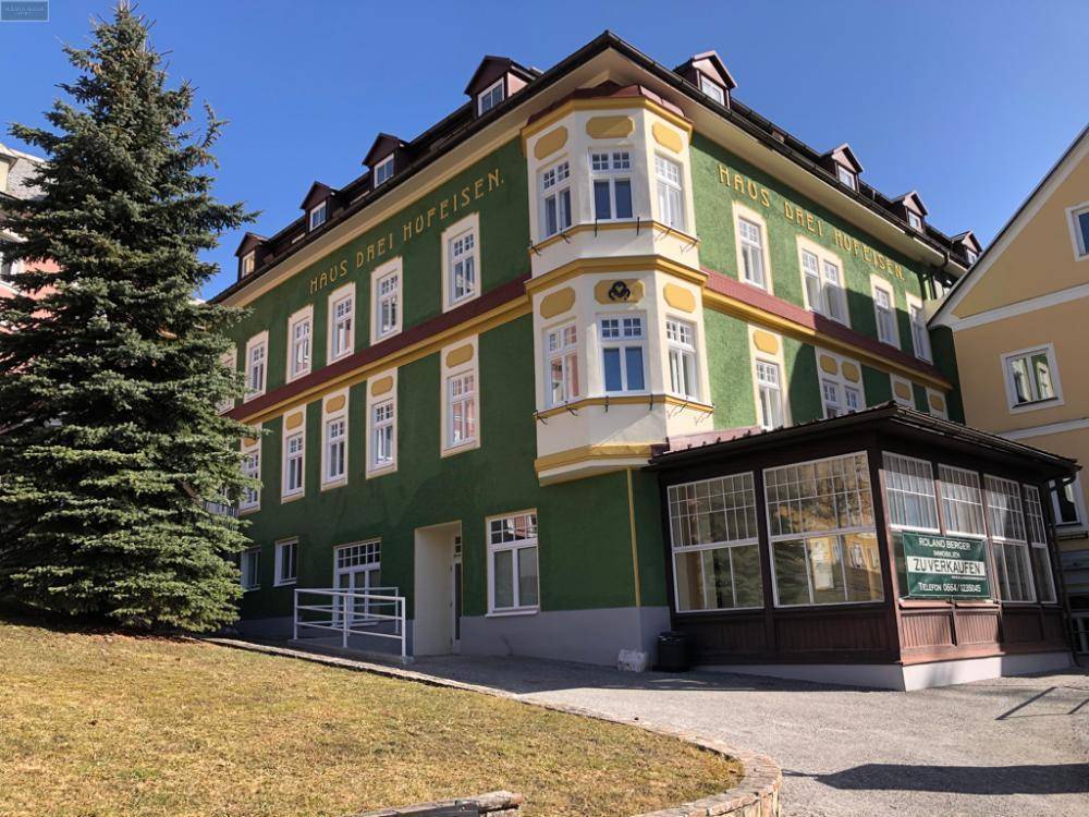 Historisches Gebäude mit markanter grüner Fassade, Erkern und traditioneller Architektur.