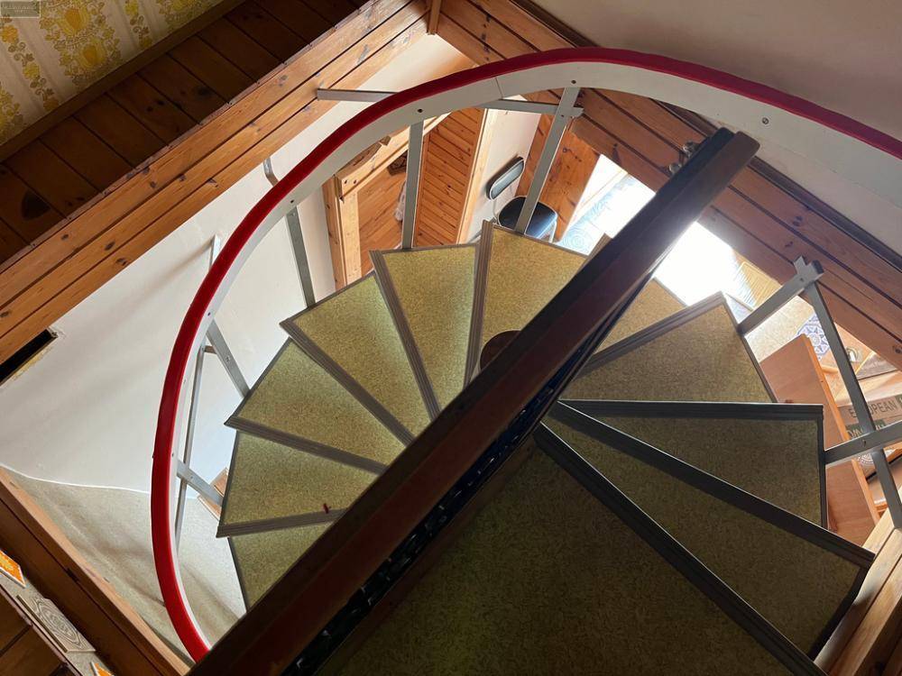 Wendeltreppe von unten gesehen, mit Holzdecke und Blick auf die obere Etage.