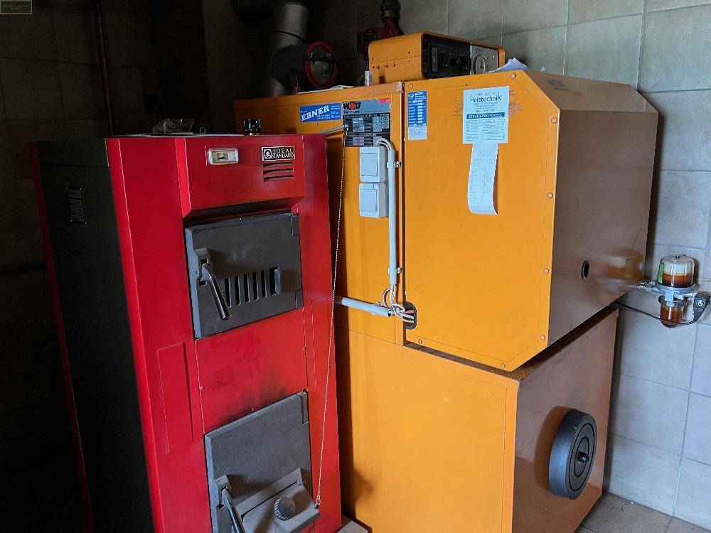 Heizungsraum mit zwei großen Heizkesseln und technischen Installationen für die Wärmeversorgung des Gebäudes.