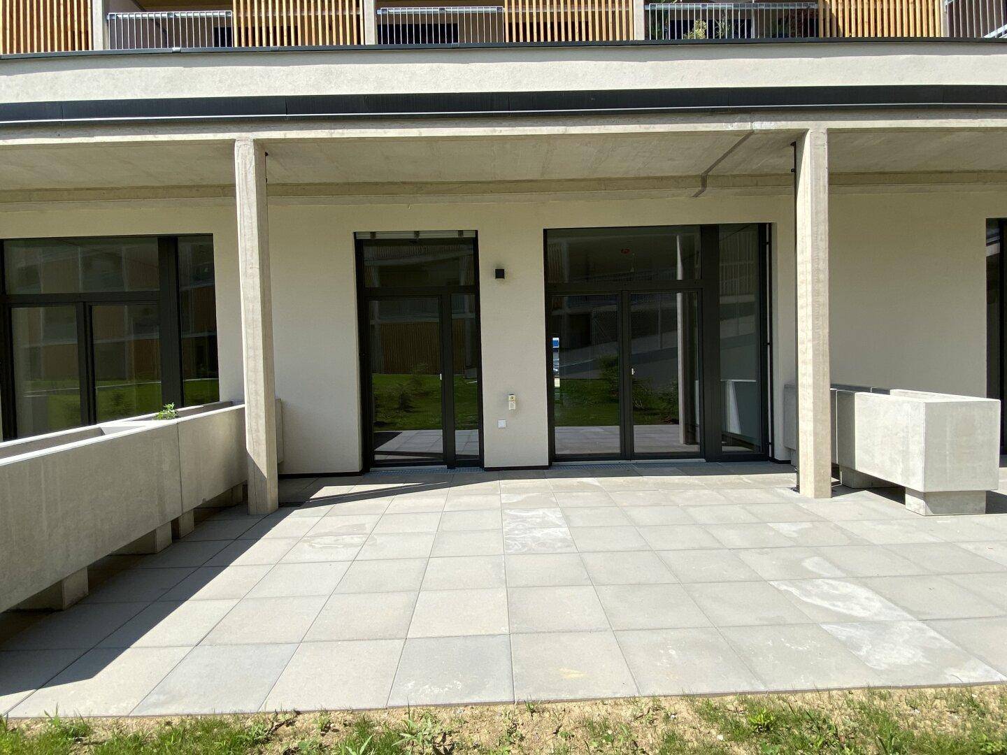 Großzügige geflieste Terrasse im Erdgeschoss mit direktem Zugang zu den Wohnräumen.