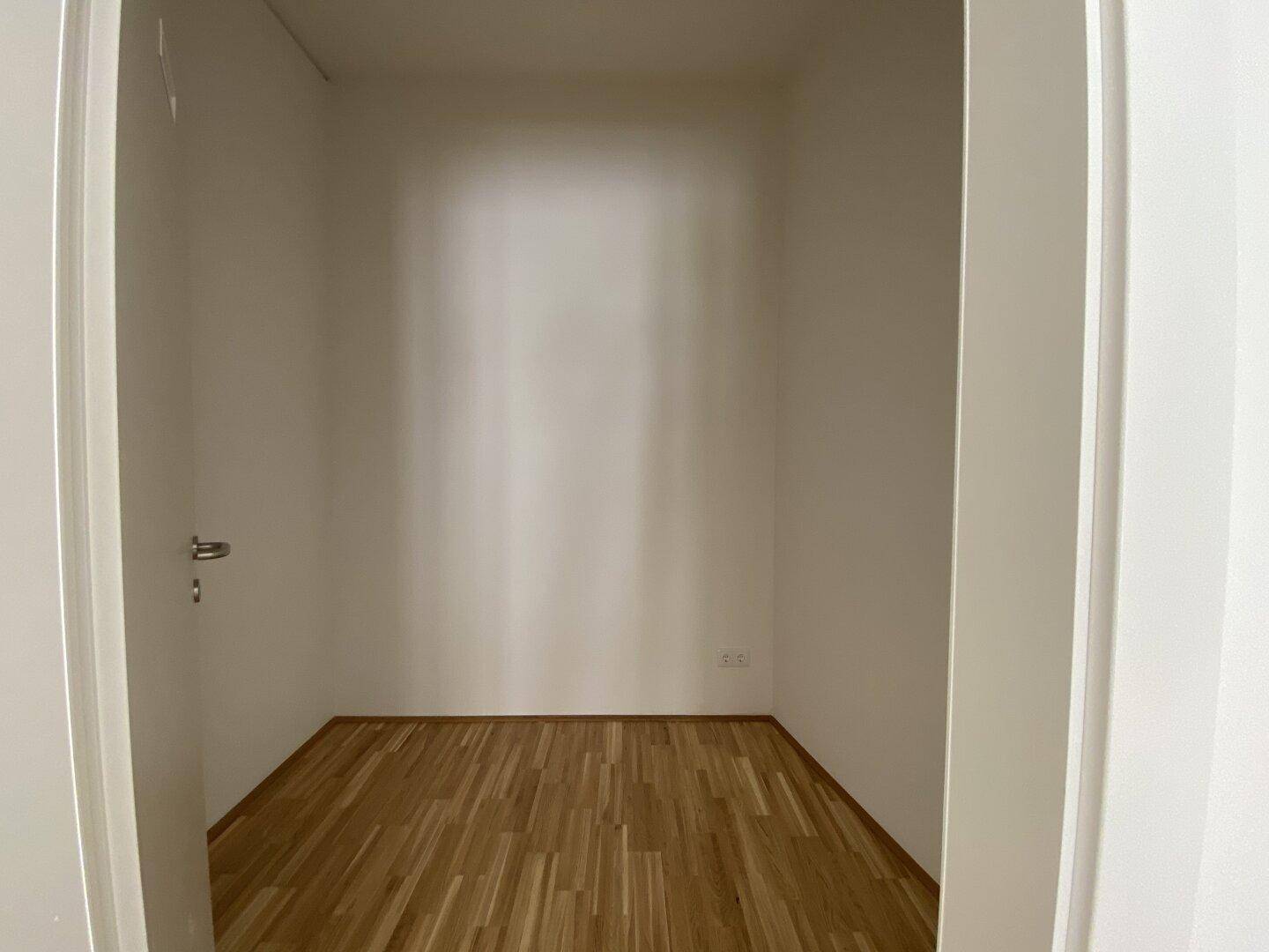Praktischer Abstellraum mit Parkettboden und weißen Wänden, ideal für zusätzlichen Stauraum.