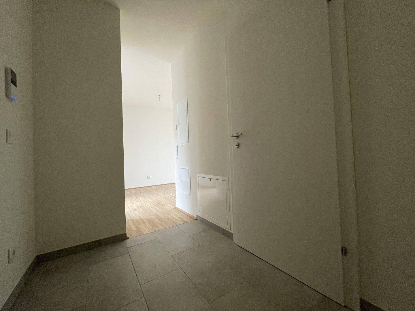 Eingangsbereich mit modernen Fliesen und Zugang zu den weiteren Räumen der Wohnung.