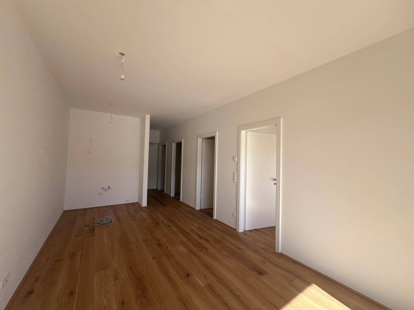 Geräumiger Flur mit Holzboden und mehreren Türen, die zu anderen Räumen führen.