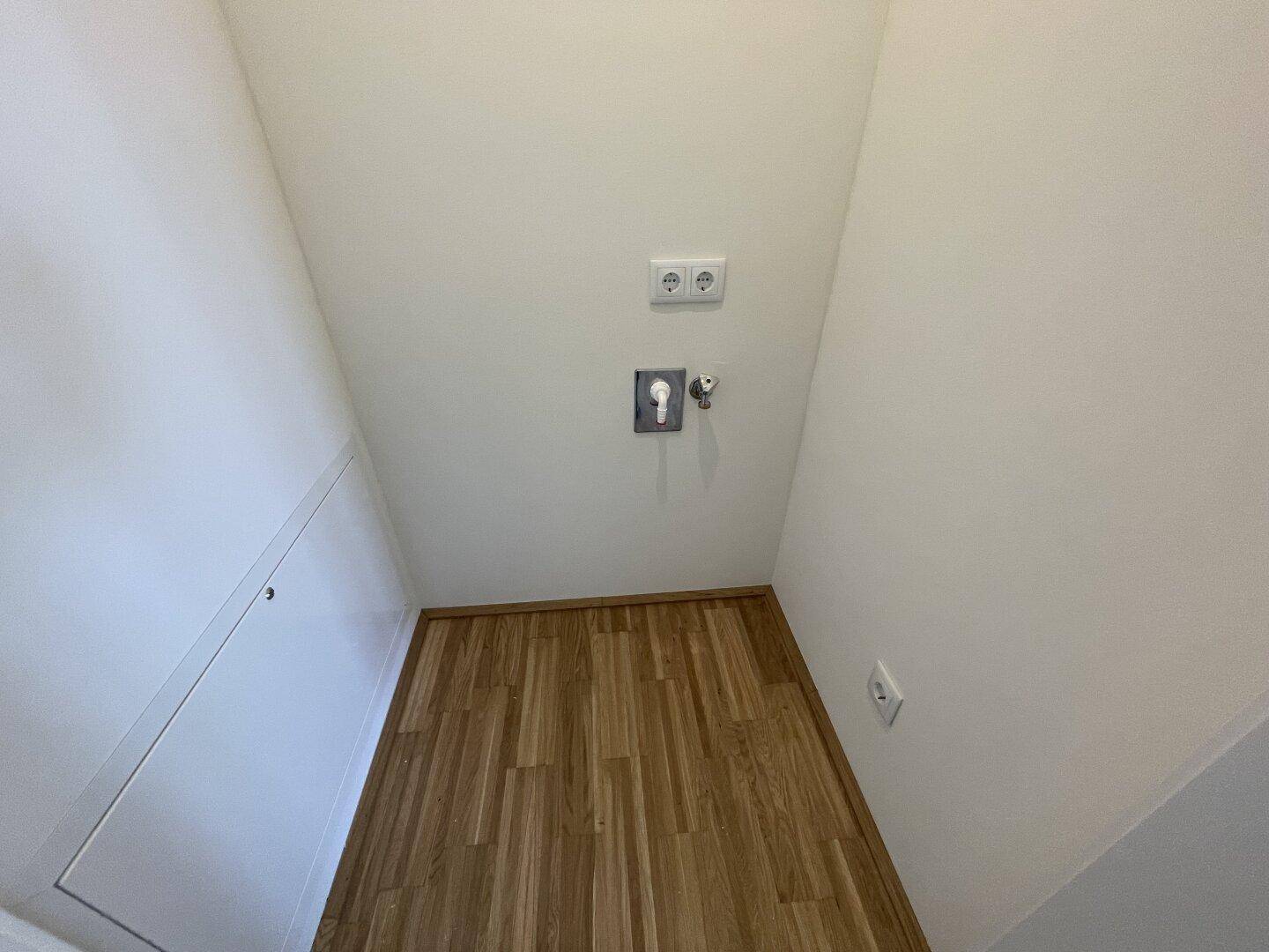 Praktischer Abstellraum mit Dachschräge und Anschlüssen für Waschmaschine oder Trockner.