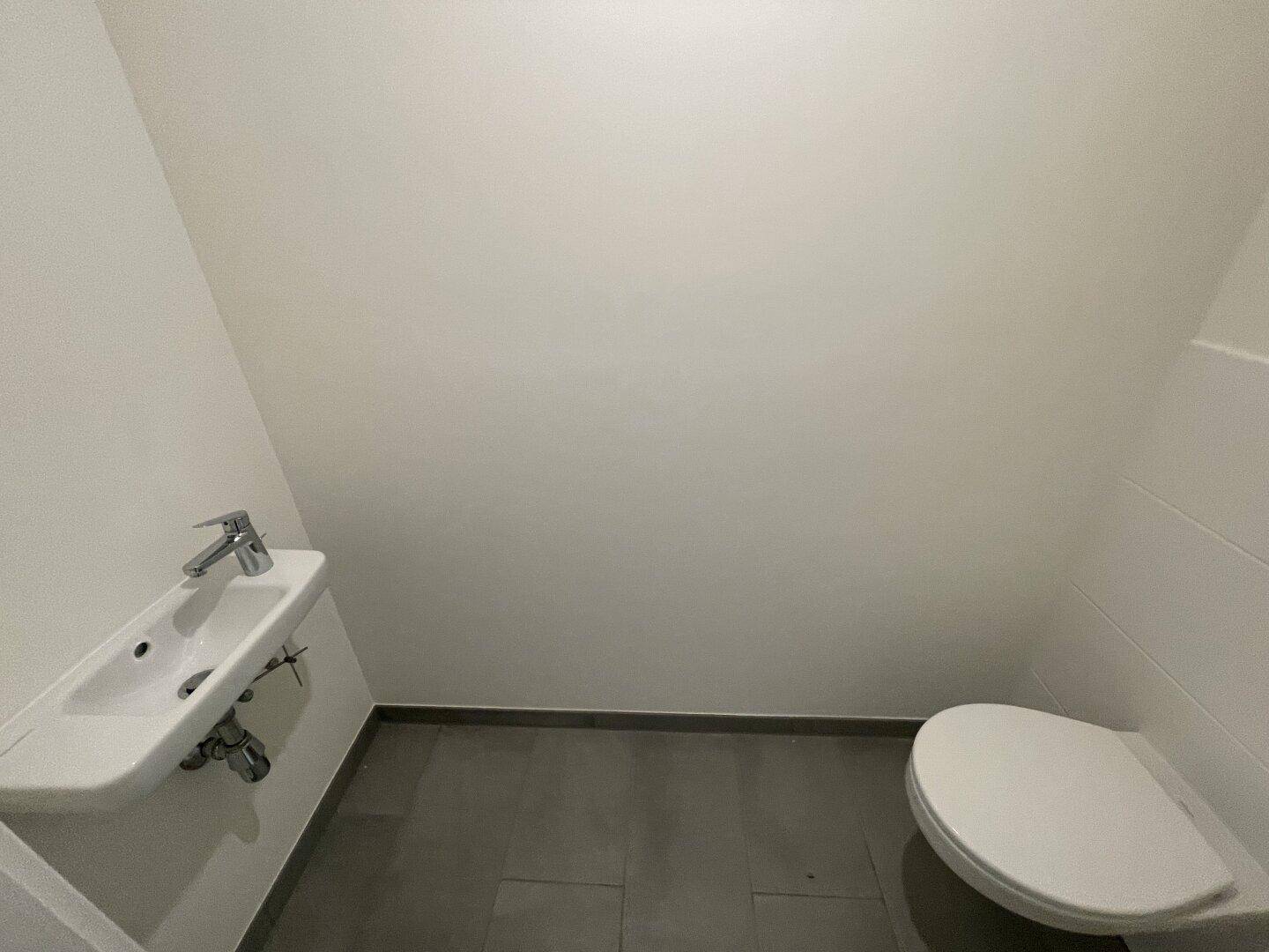 Kompaktes Gäste-WC mit modernem Design, Wand-WC und kleinem Waschbecken.