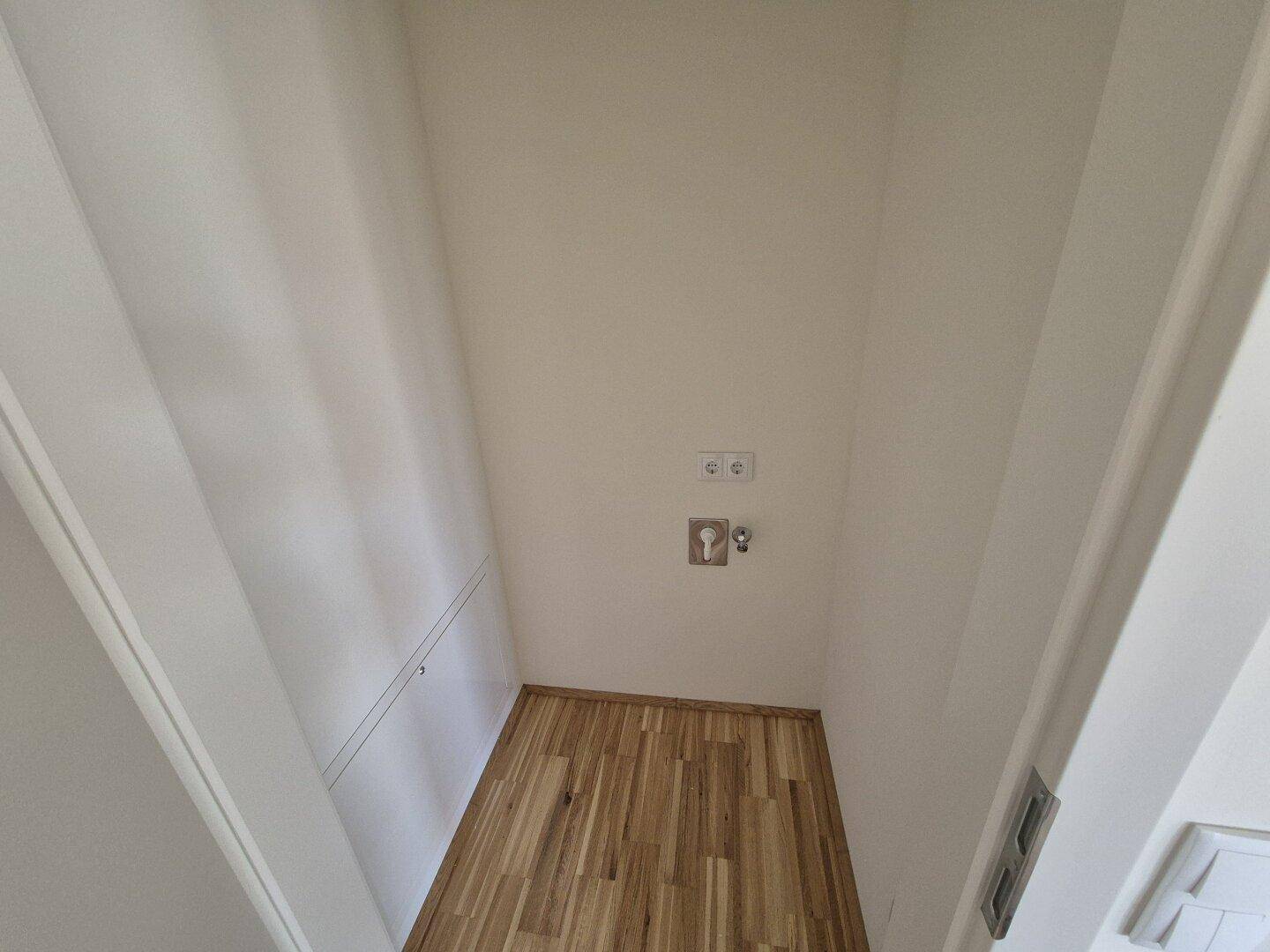 Kleiner Hauswirtschaftsraum mit Anschlüssen für Waschmaschine und Trockner.