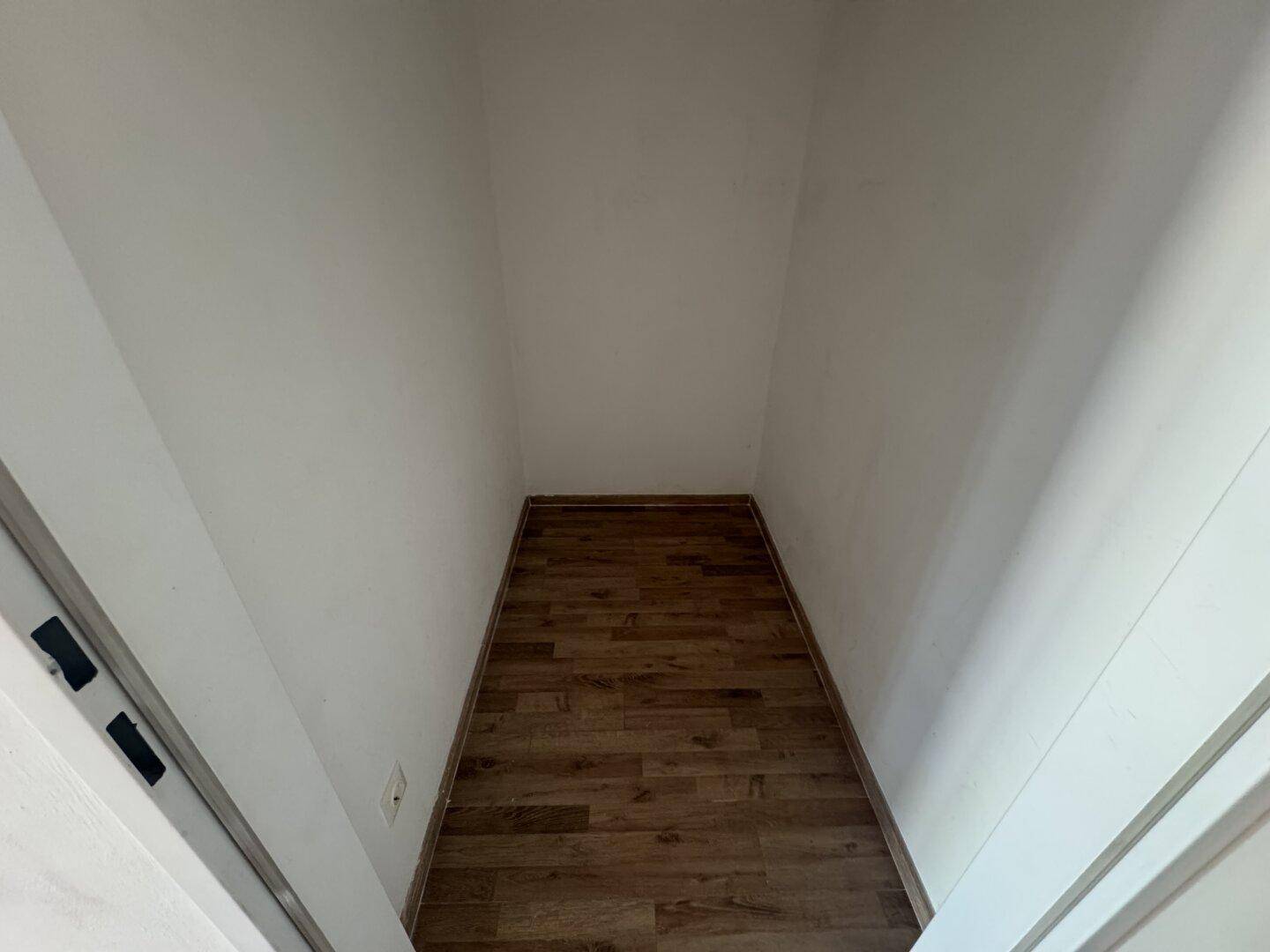 Praktischer Abstellraum mit Laminatboden und weißen Wänden, bietet zusätzlichen Stauraum.