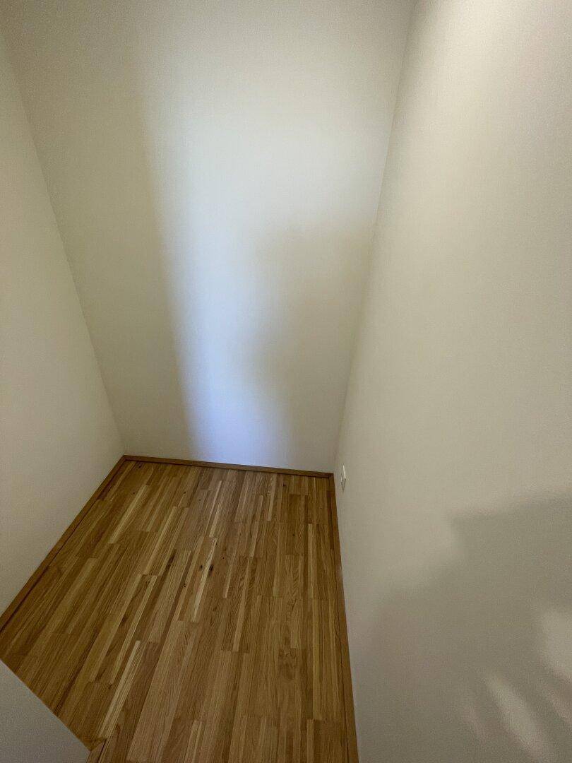 Kleiner, leerer Abstellraum mit Parkettboden, ideal für zusätzlichen Stauraum.