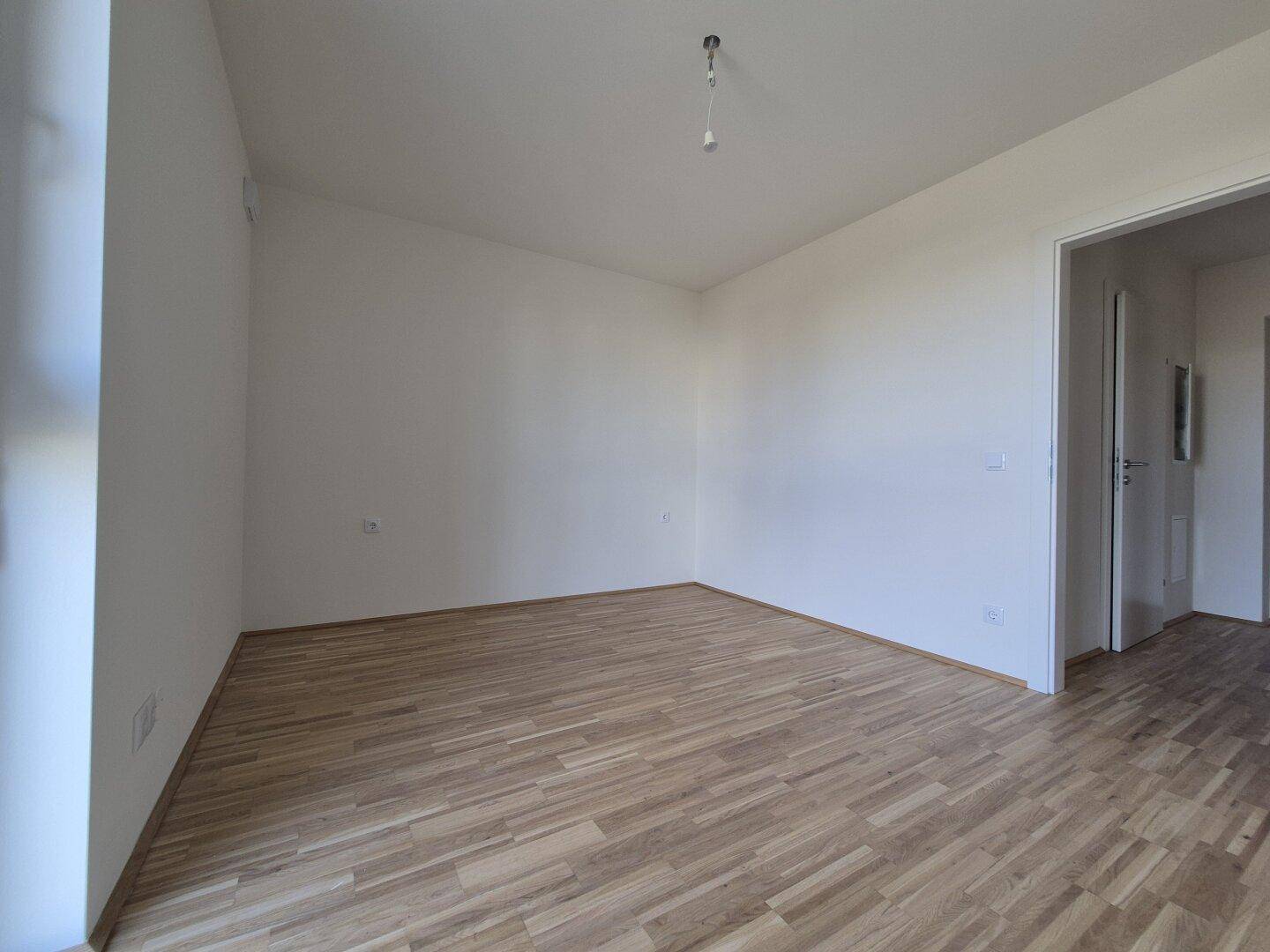 Unmöblierter Raum mit Parkettboden und weißen Wänden, ideal für ein Schlaf- oder Wohnzimmer.