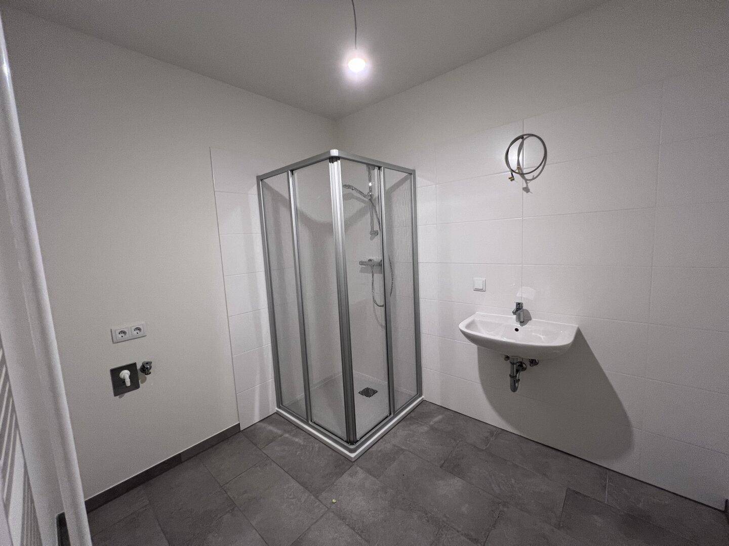 Modernes Badezimmer mit Duschkabine, Einzelwaschbecken und Handtuchheizkörper.