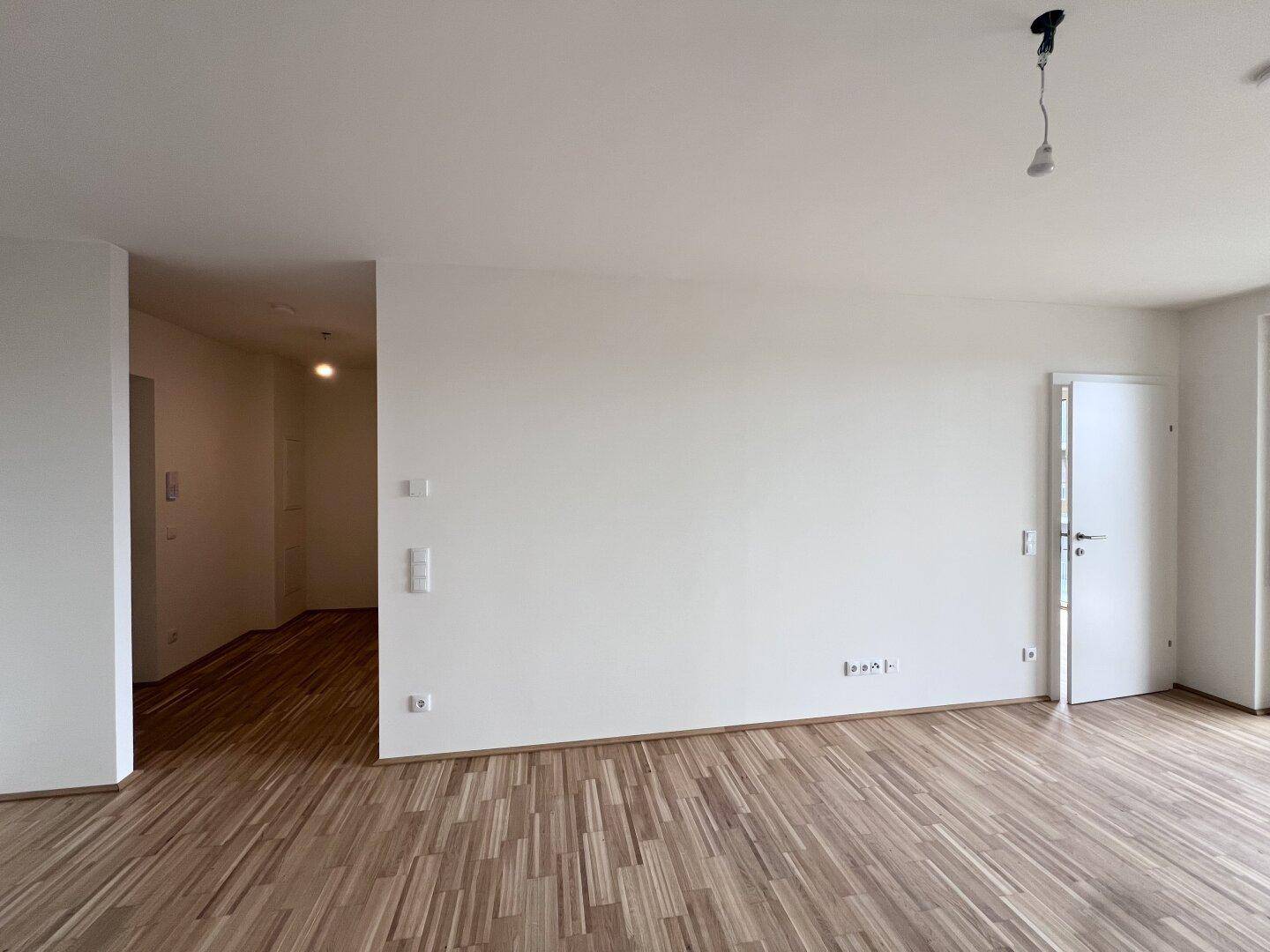 Heller Innenraum mit Parkettboden und weiß gestrichenen Wänden, ideal für individuelle Gestaltung.