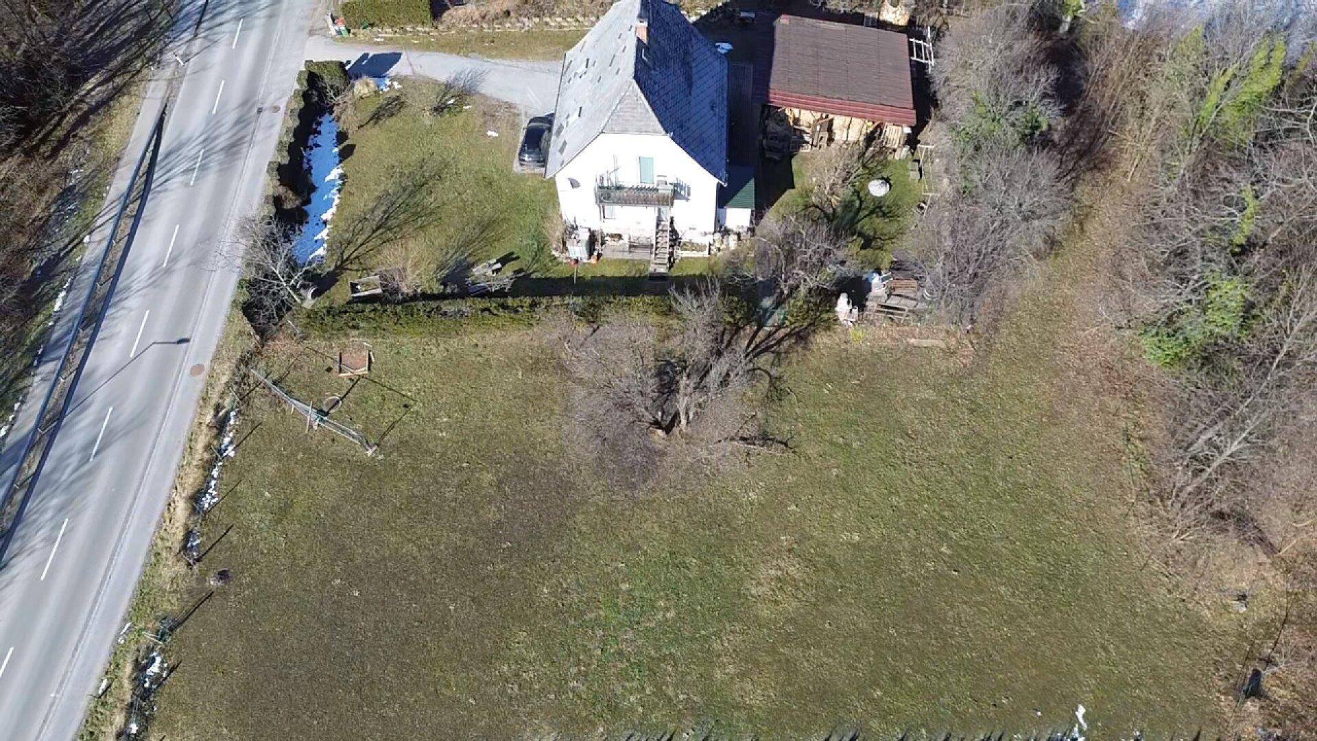 Senkrechte Luftaufnahme eines Hauses mit angrenzendem Grundstück und einer Straße.