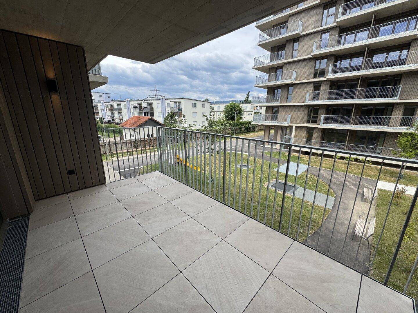 Balkon mit Blick auf die umliegenden Wohngebäude und einen Spielplatz.