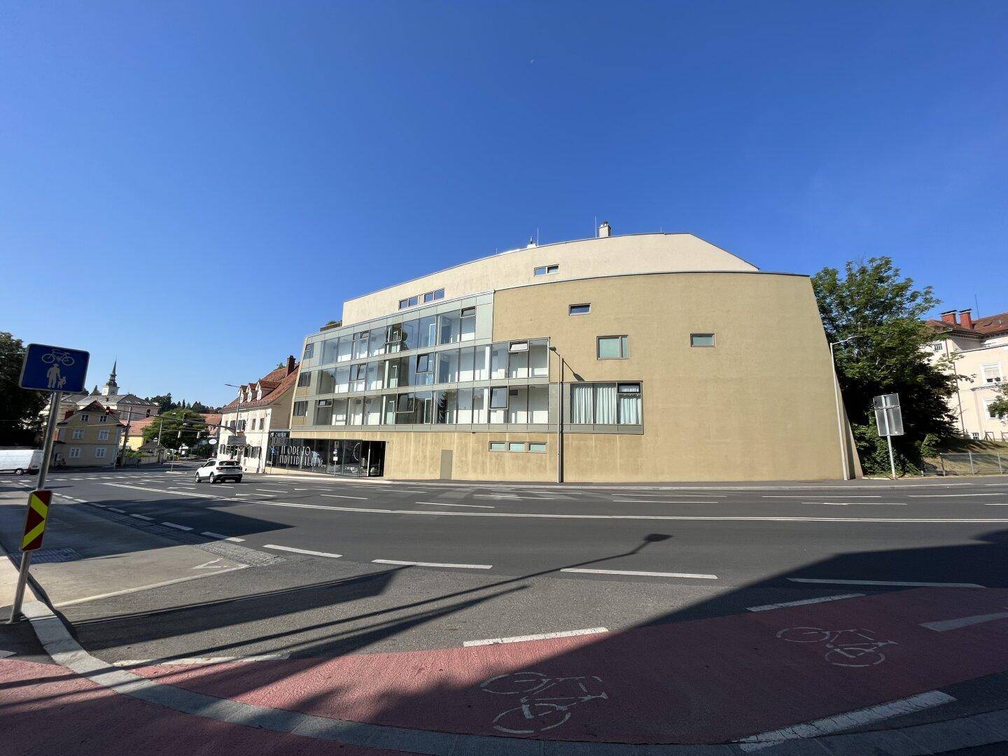 Moderne Architektur des Gebäudes an einer städtischen Straße mit klarem Himmel.