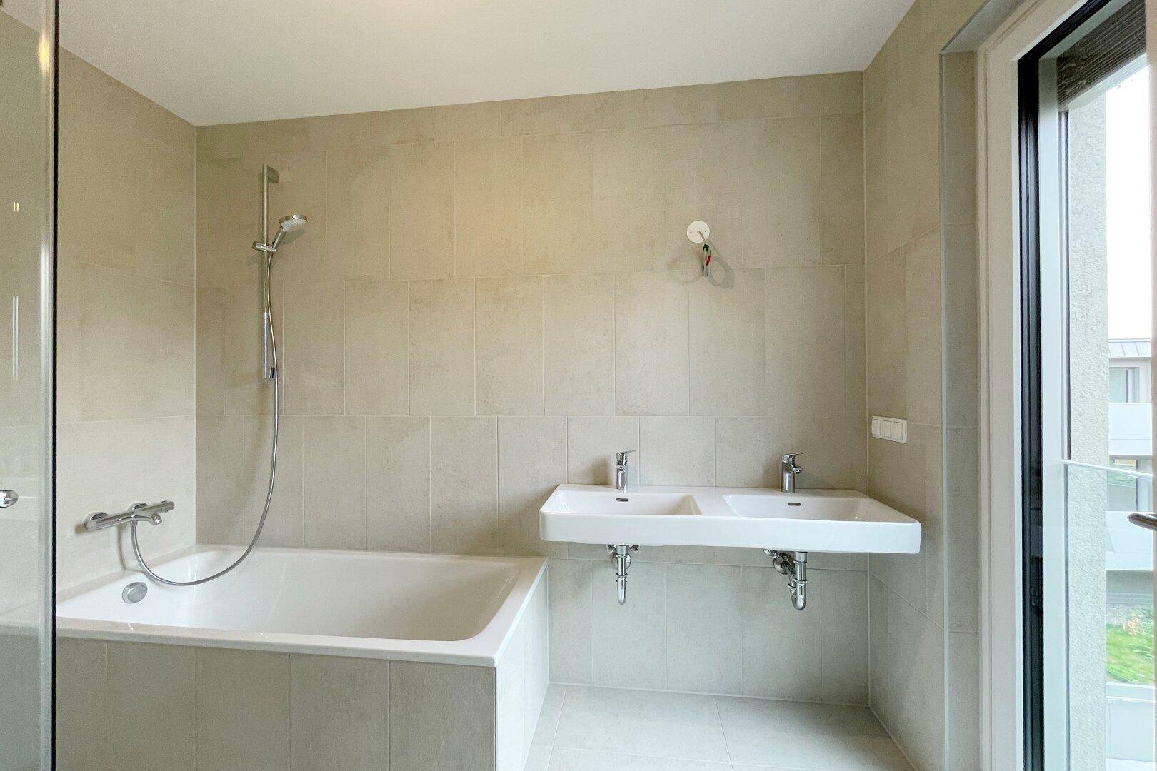 Modernes Badezimmer mit Badewanne, Dusche und Doppelwaschbecken.