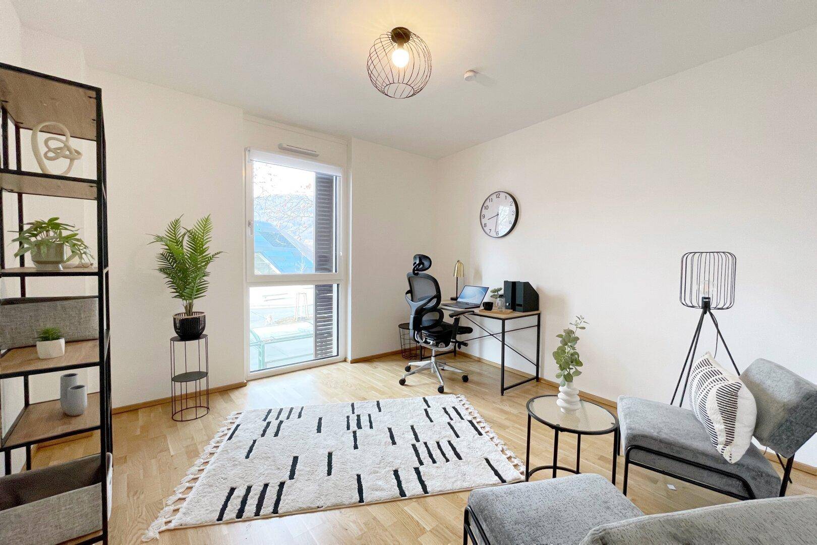 Freundliches Arbeitszimmer mit Holzboden, großem Fenster und moderner Einrichtung, ideal für Home-Office.