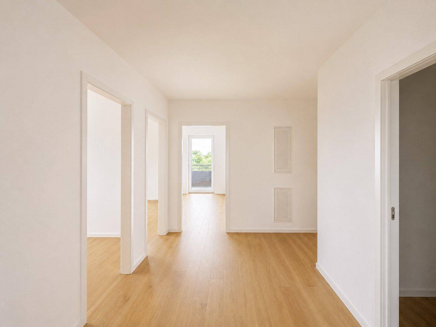 Heller Flur mit Holzboden und mehreren Türen zu angrenzenden Räumen.