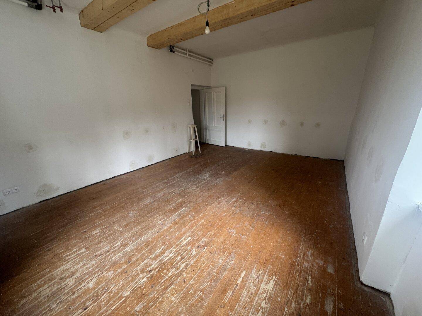 Heller Raum mit Holzbalken und Dielenboden, ideal für individuelle Gestaltung.