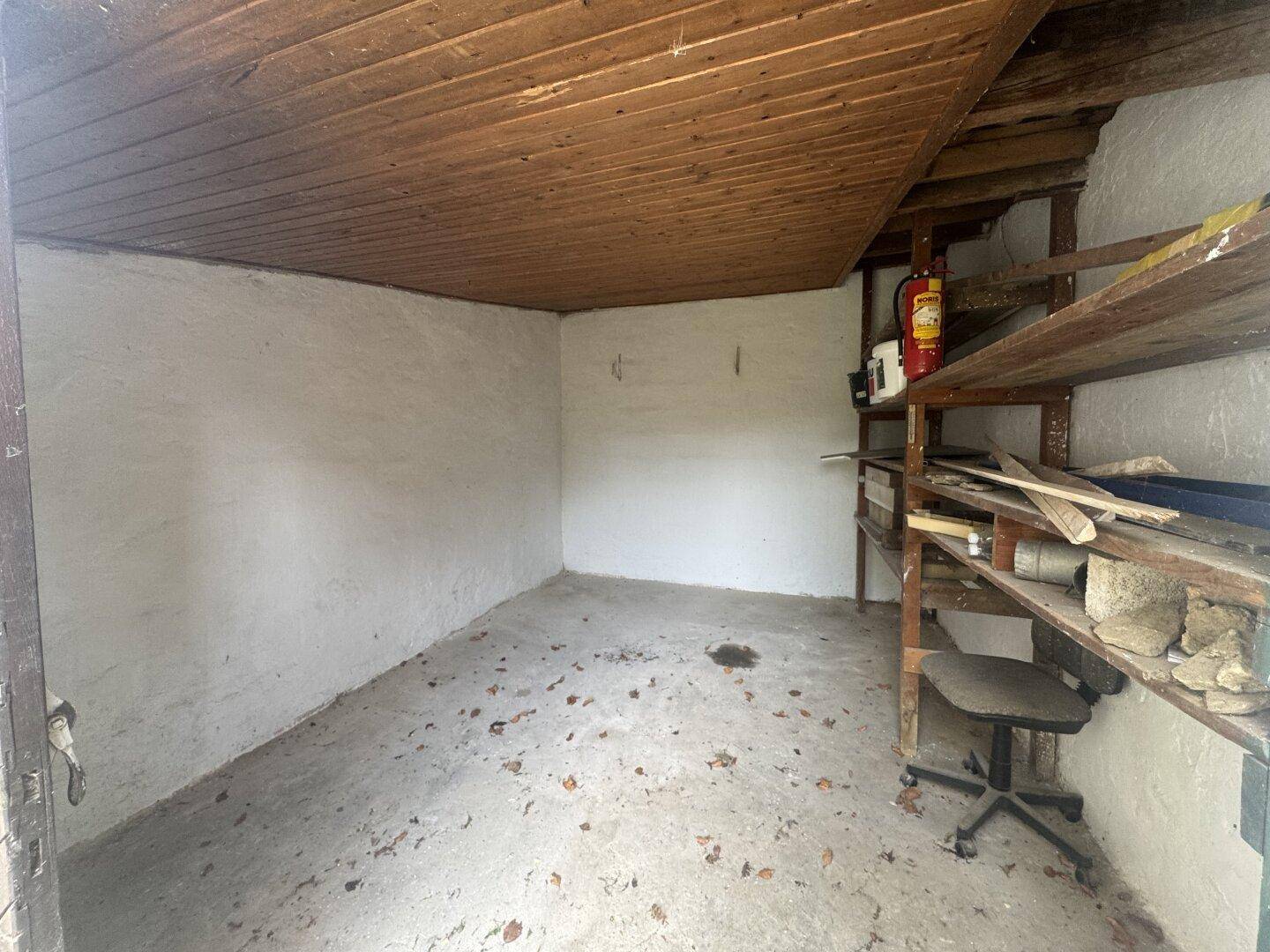 Abstellraum mit Holzdecke und Regalen, ideal für Lagerzwecke.