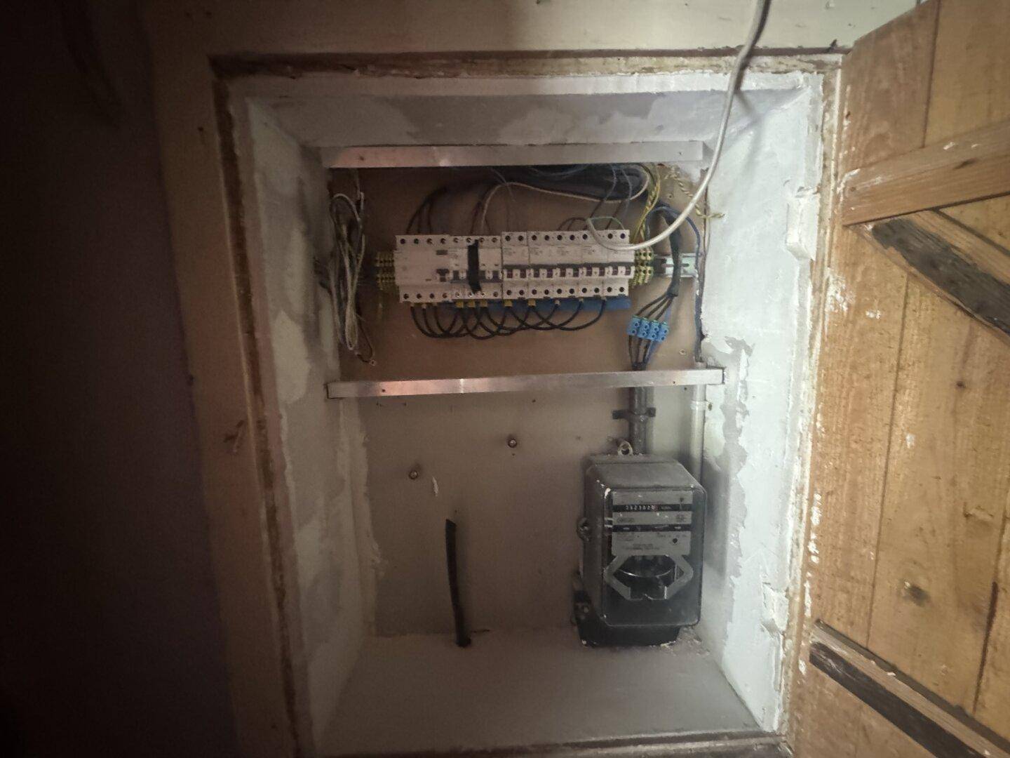 Elektrischer Sicherungskasten und Zähler in einem Technikraum.