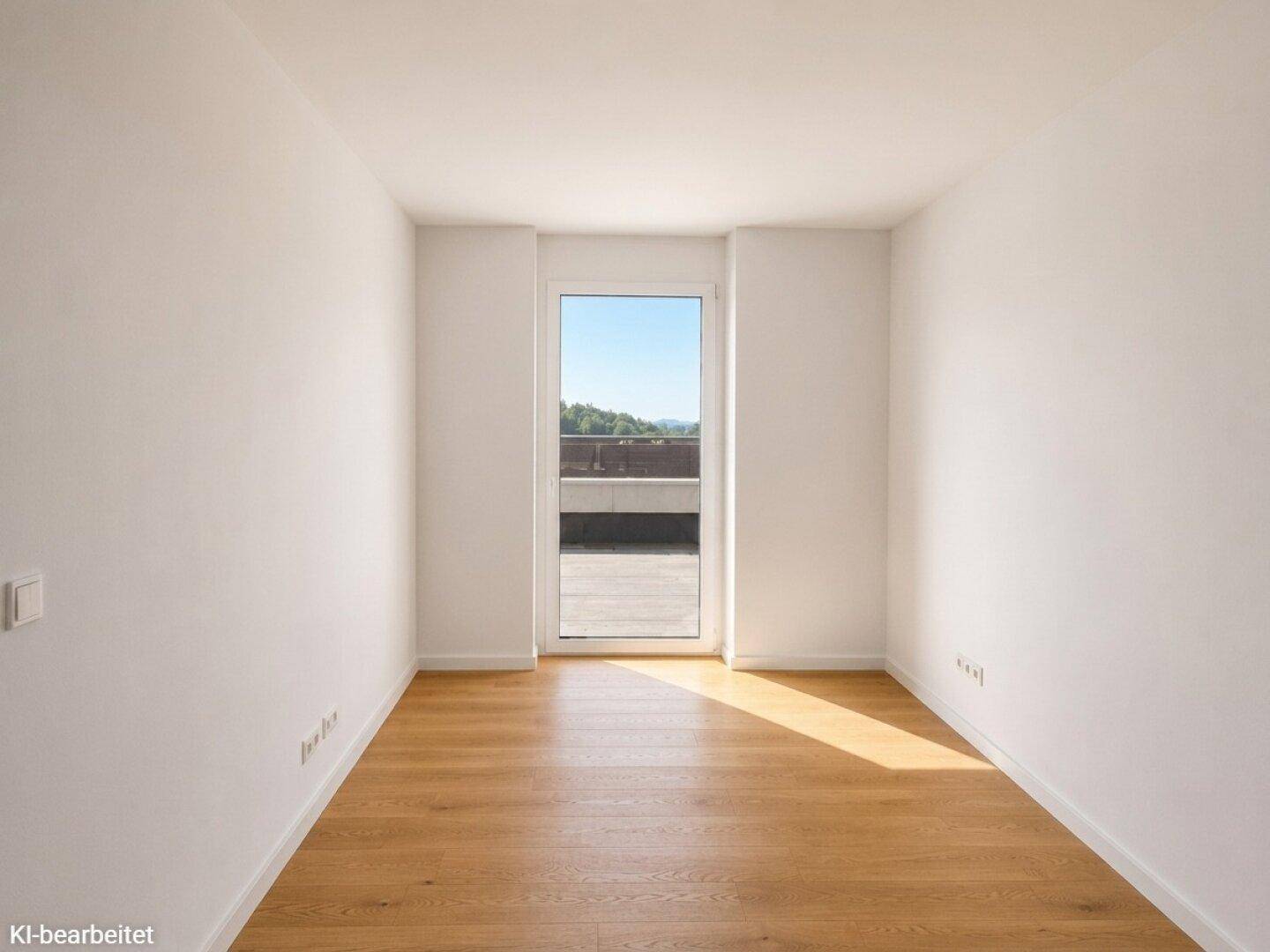 Heller Raum mit Holzboden und einer Tür, die zu einem sonnigen Außenbereich führt.
