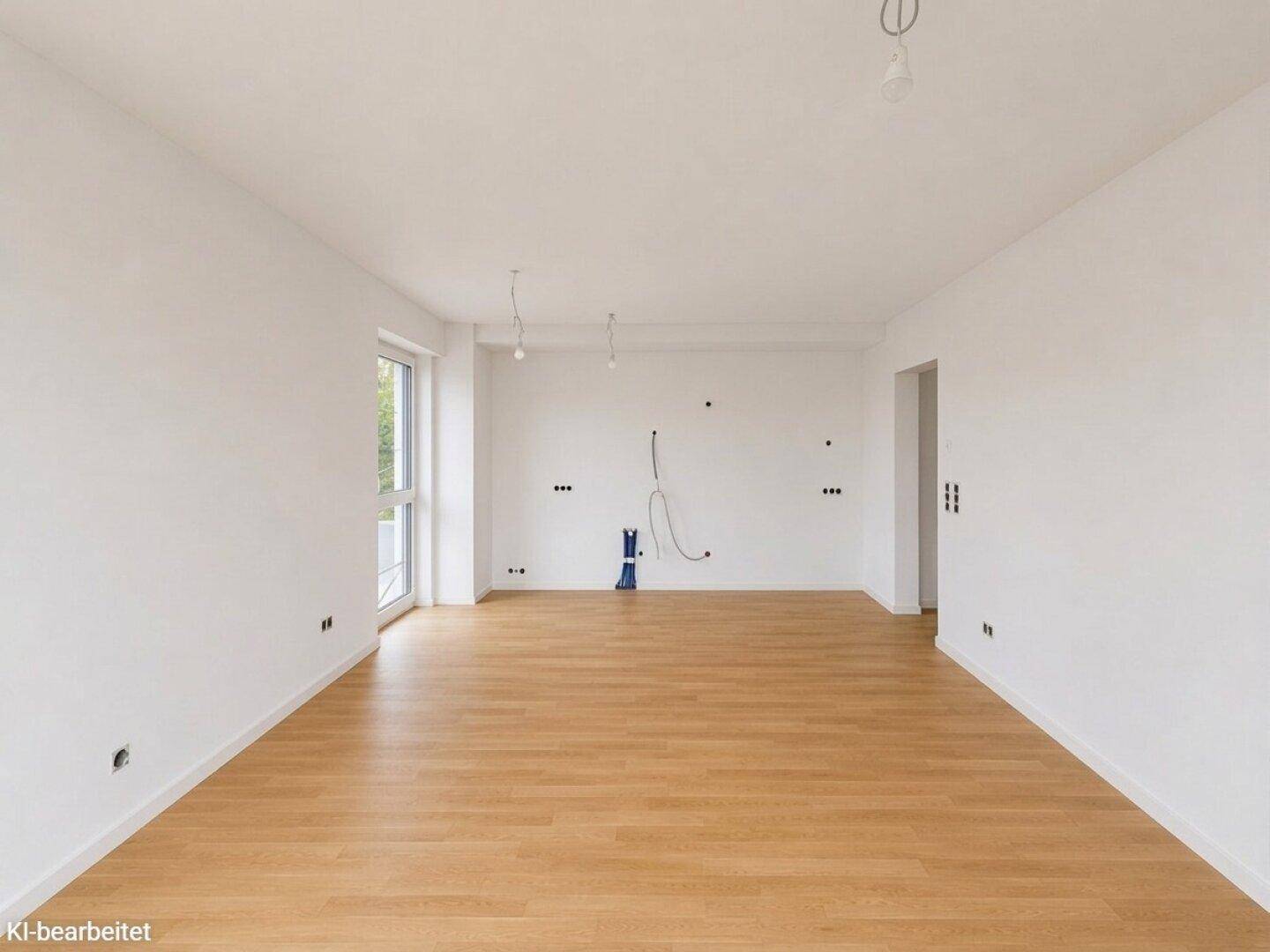 Unmöblierter Raum mit Holzboden und sichtbaren Elektroinstallationen, bereit für den Ausbau.