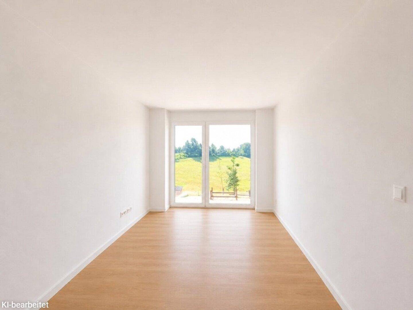 Lichtdurchfluteter Raum mit Holzboden und Panoramafenstern, die eine offene Landschaft zeigen.