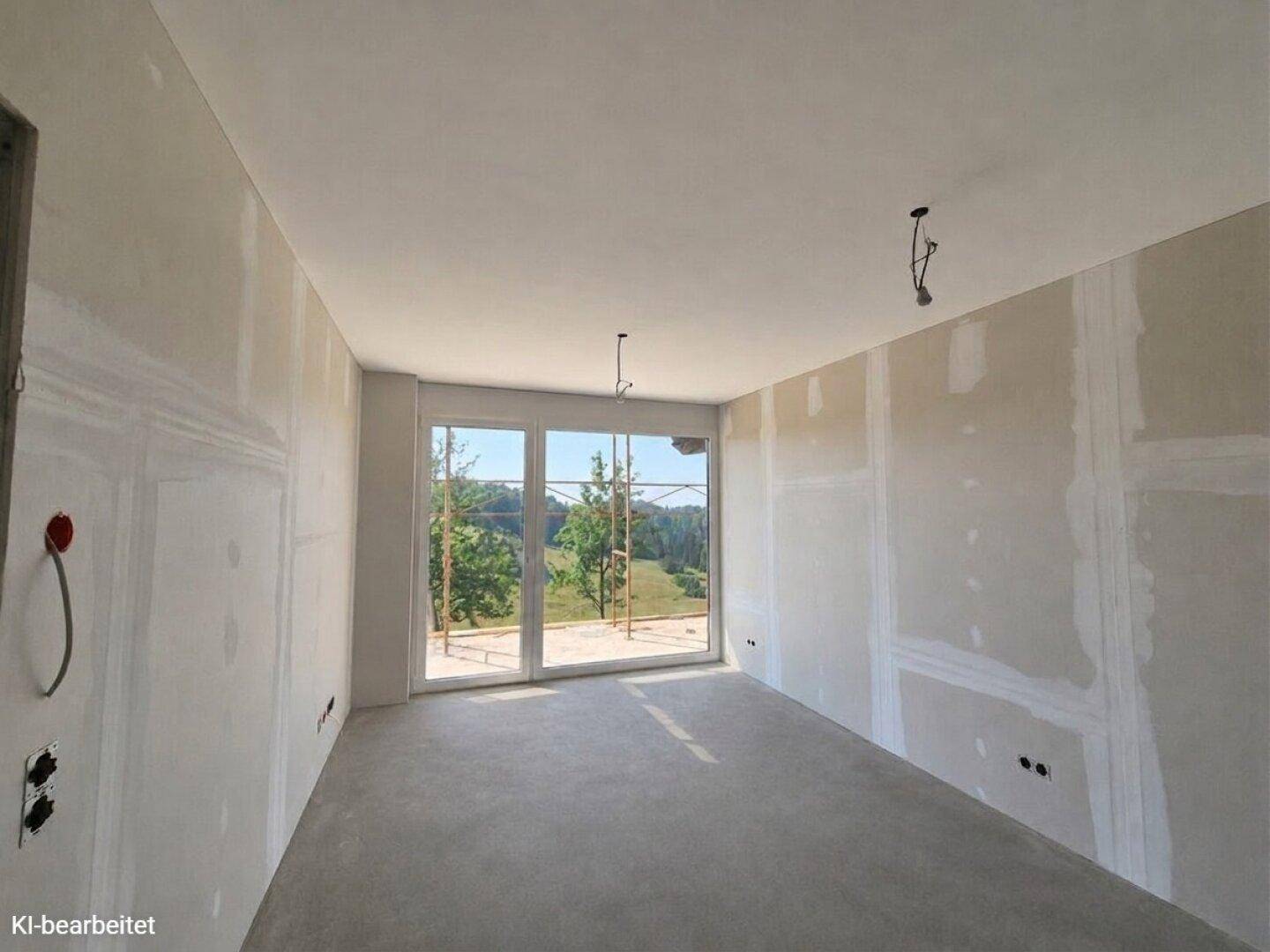 Unfertiges Zimmer mit Betonboden und großen Fenstern, die einen weiten Blick in die Natur ermöglichen.