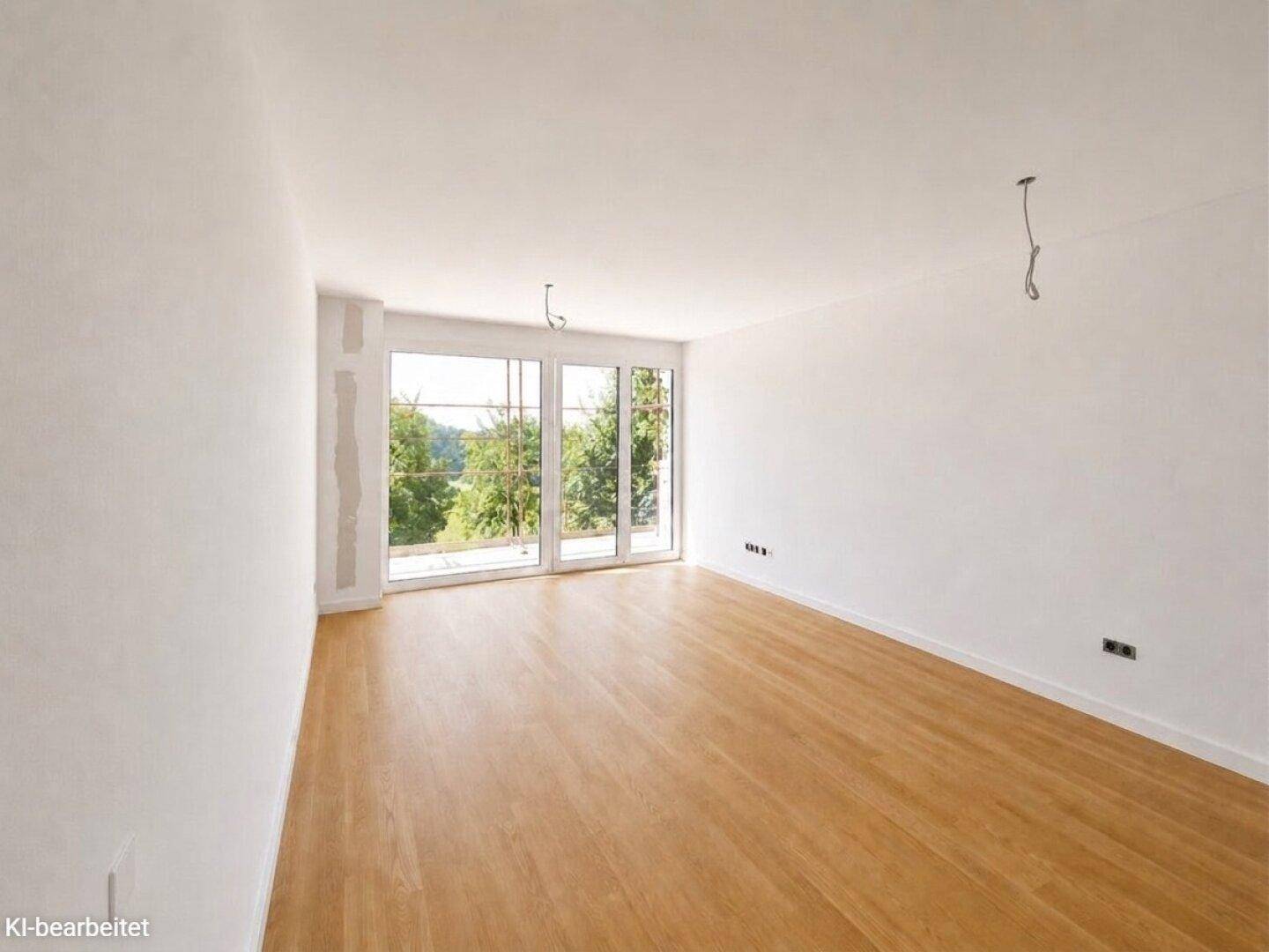 Geräumiges Zimmer mit Holzboden und großen Fenstern, die einen weiten Blick ins Grüne bieten.
