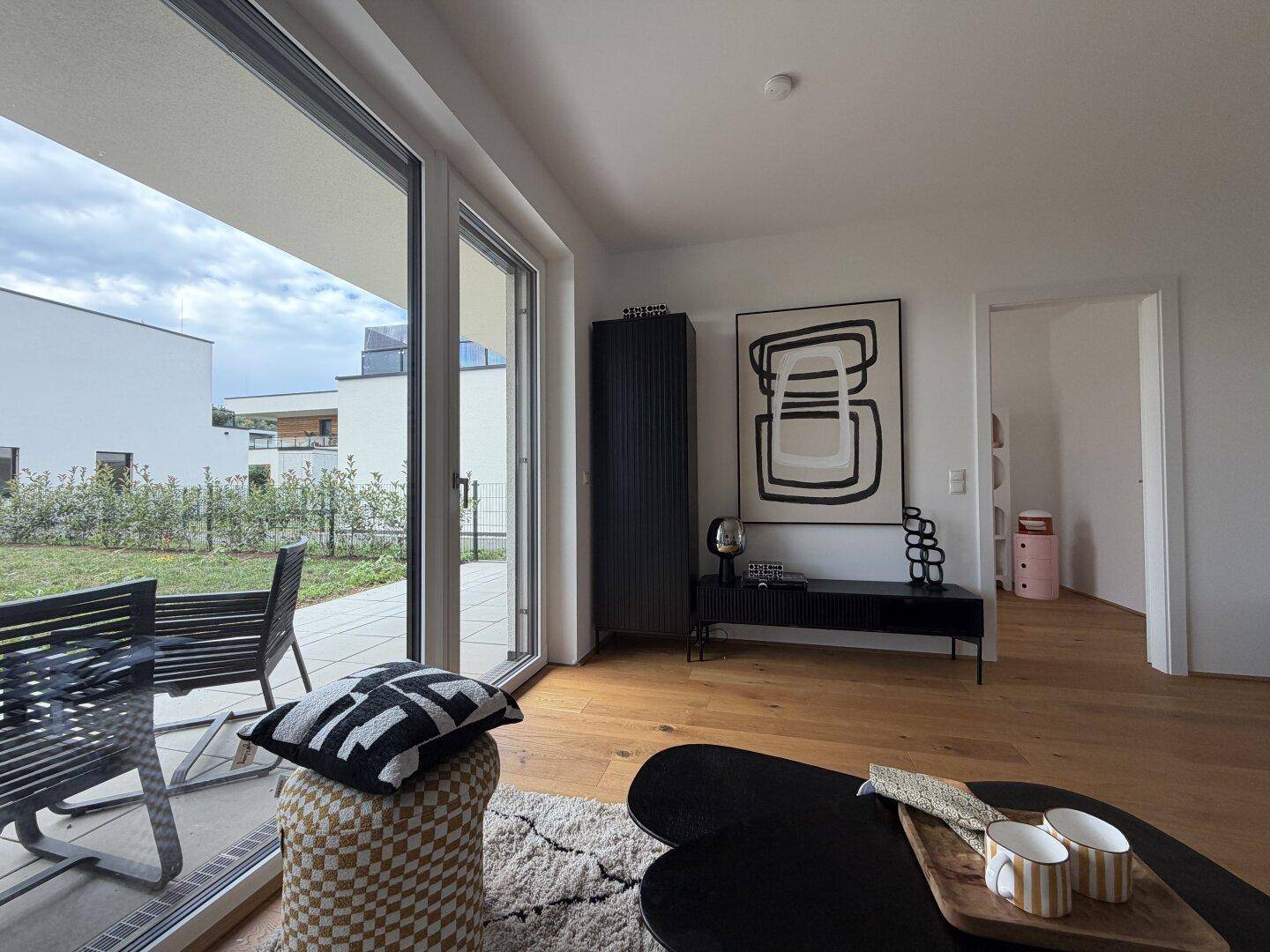 Heller Wohnbereich mit großen Schiebetüren, die zur Terrasse und zum Garten führen.