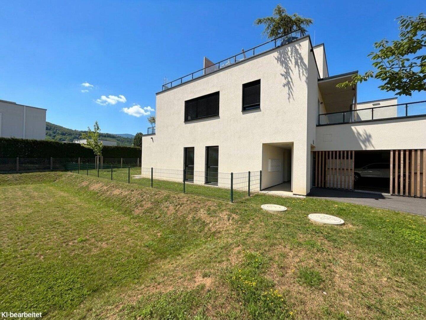 Moderne Architektur mit Flachdach, großen Fenstern und integrierter Garage in grüner Umgebung.