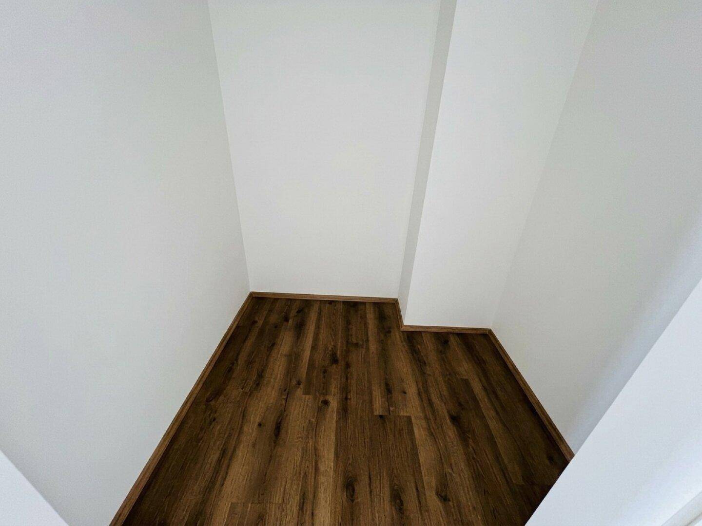 Kleiner, leerer Raum mit Laminatboden, ideal als Abstellraum oder begehbarer Kleiderschrank.