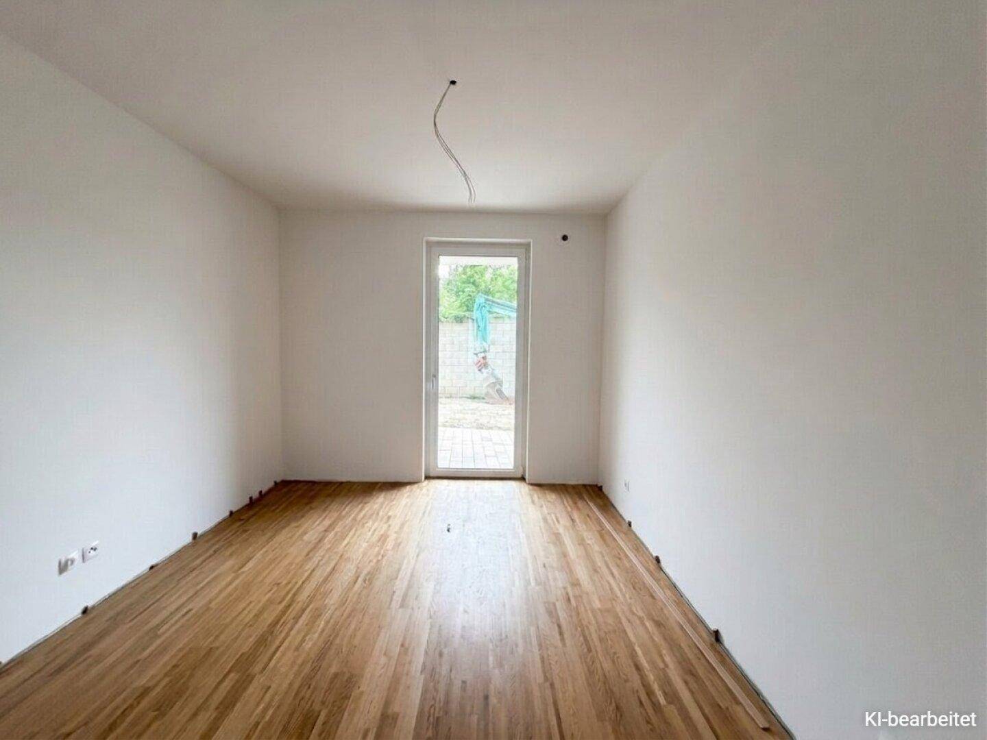 Leeres Zimmer mit Parkettboden und direktem Zugang zum Außenbereich, bereit zur individuellen Gestaltung.