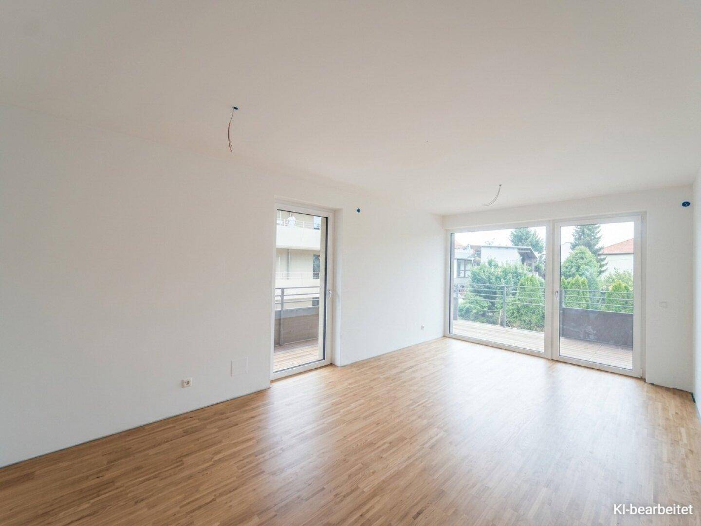 Lichtdurchfluteter Wohnraum mit Holzboden und großen Fenstern, die viel Tageslicht hereinlassen.