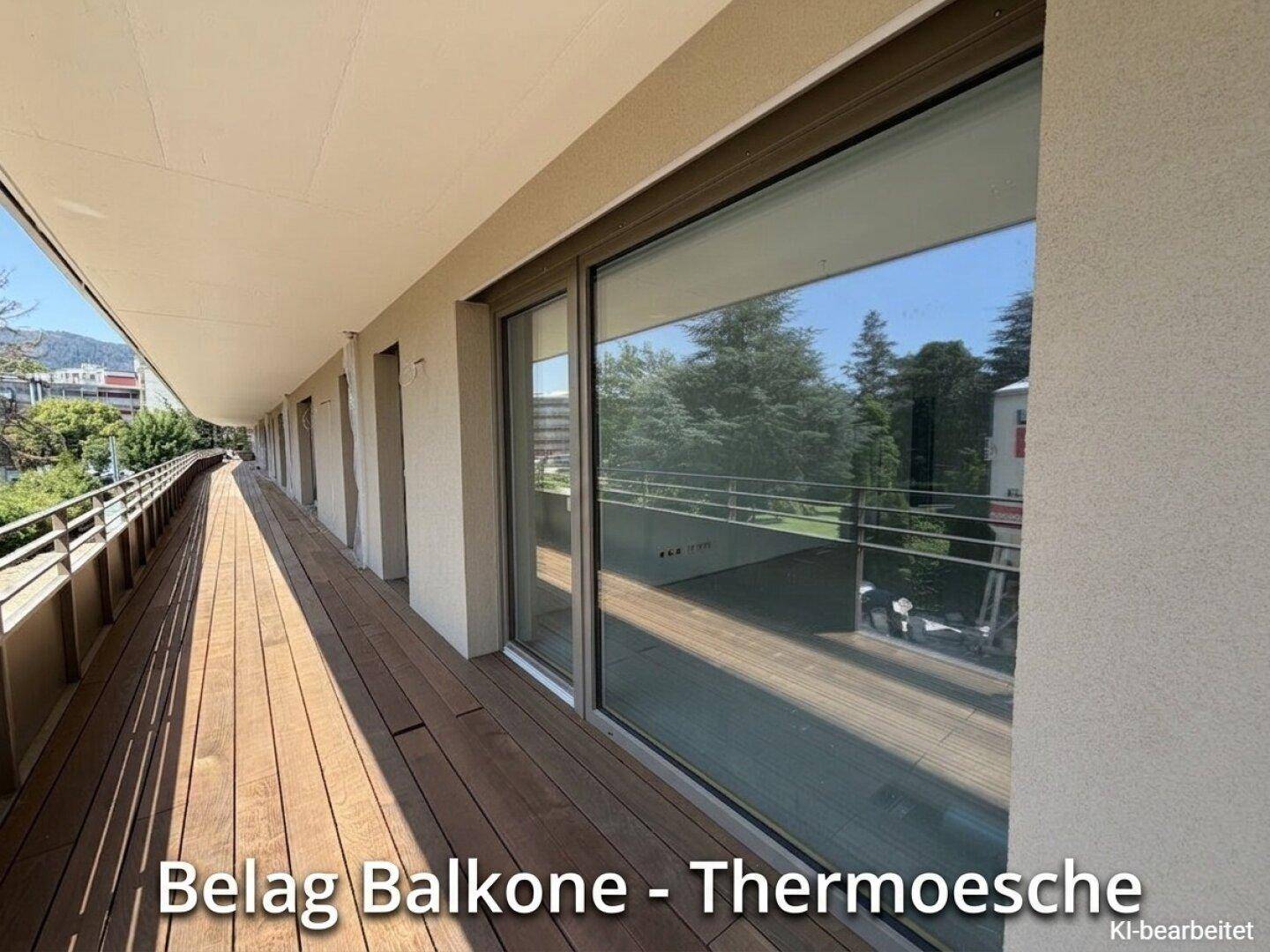 Langer Balkon mit Holzbelag und Glasbrüstung, bietet einen weiten Blick auf die Umgebung.