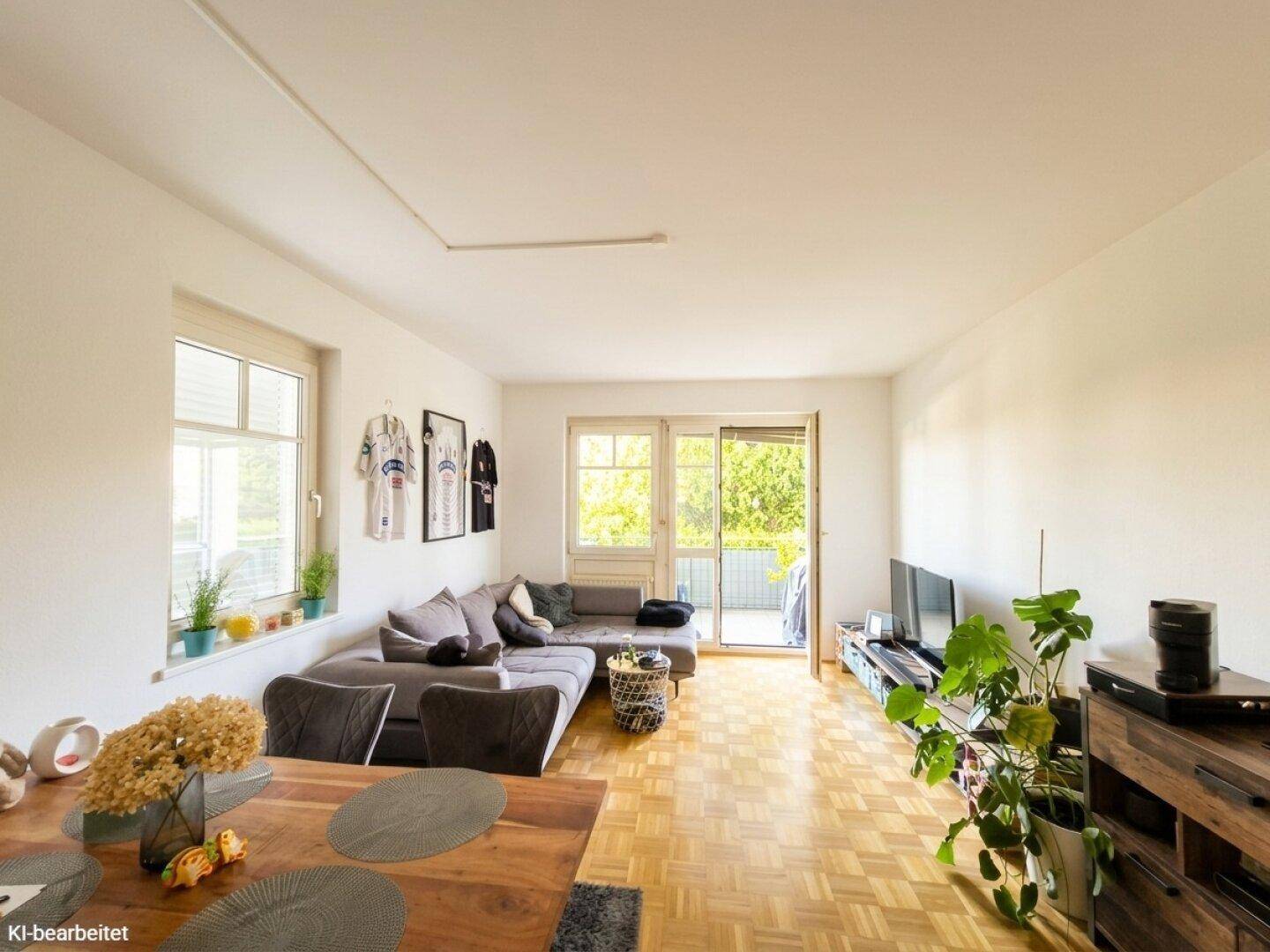 Helles Wohnzimmer mit großem Sofa, Fernseher und Zugang zum Balkon, kombiniert mit Essbereich.