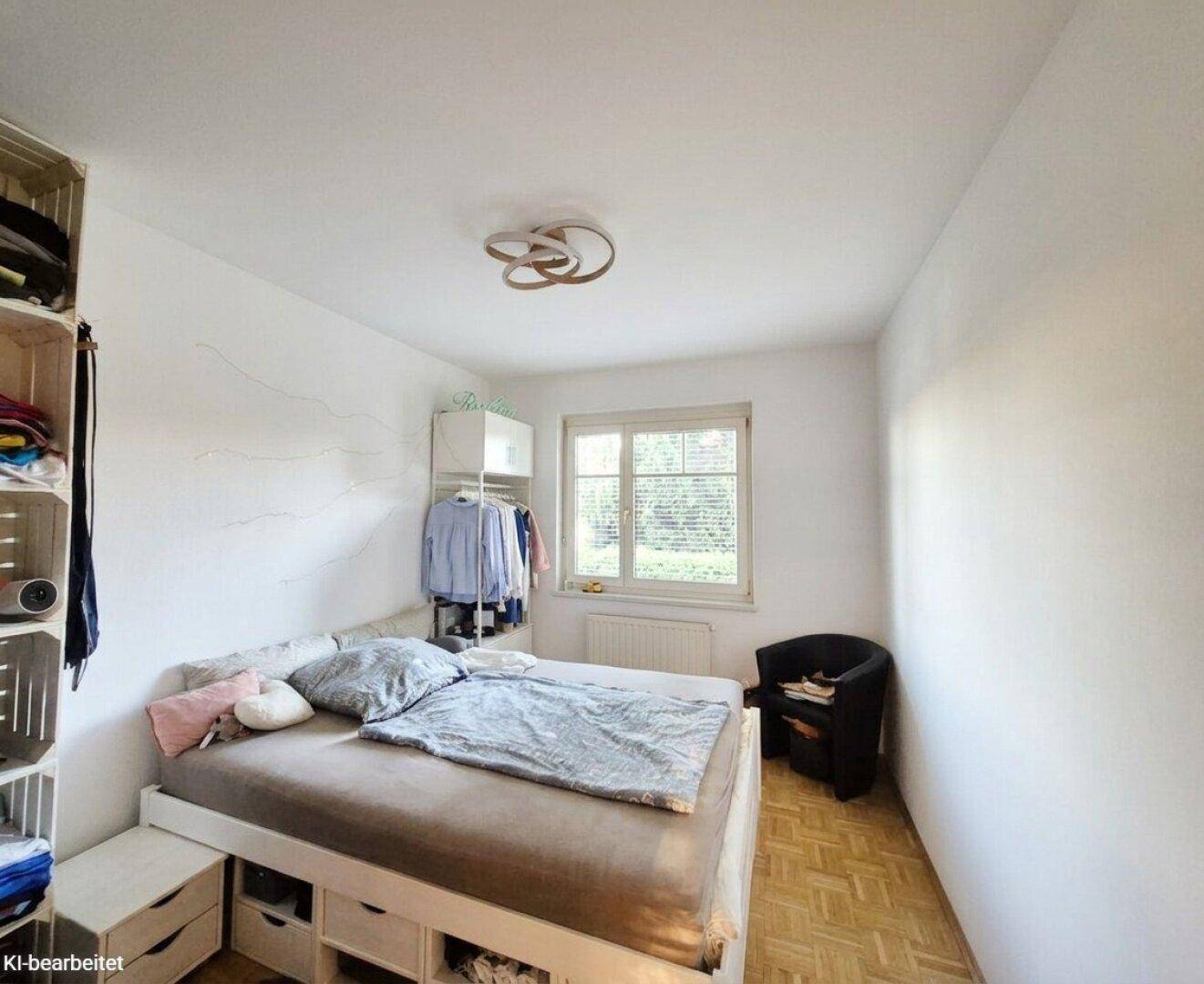 Schlafzimmer mit Bett, praktischen Regalen und einem Fenster für natürliches Licht.