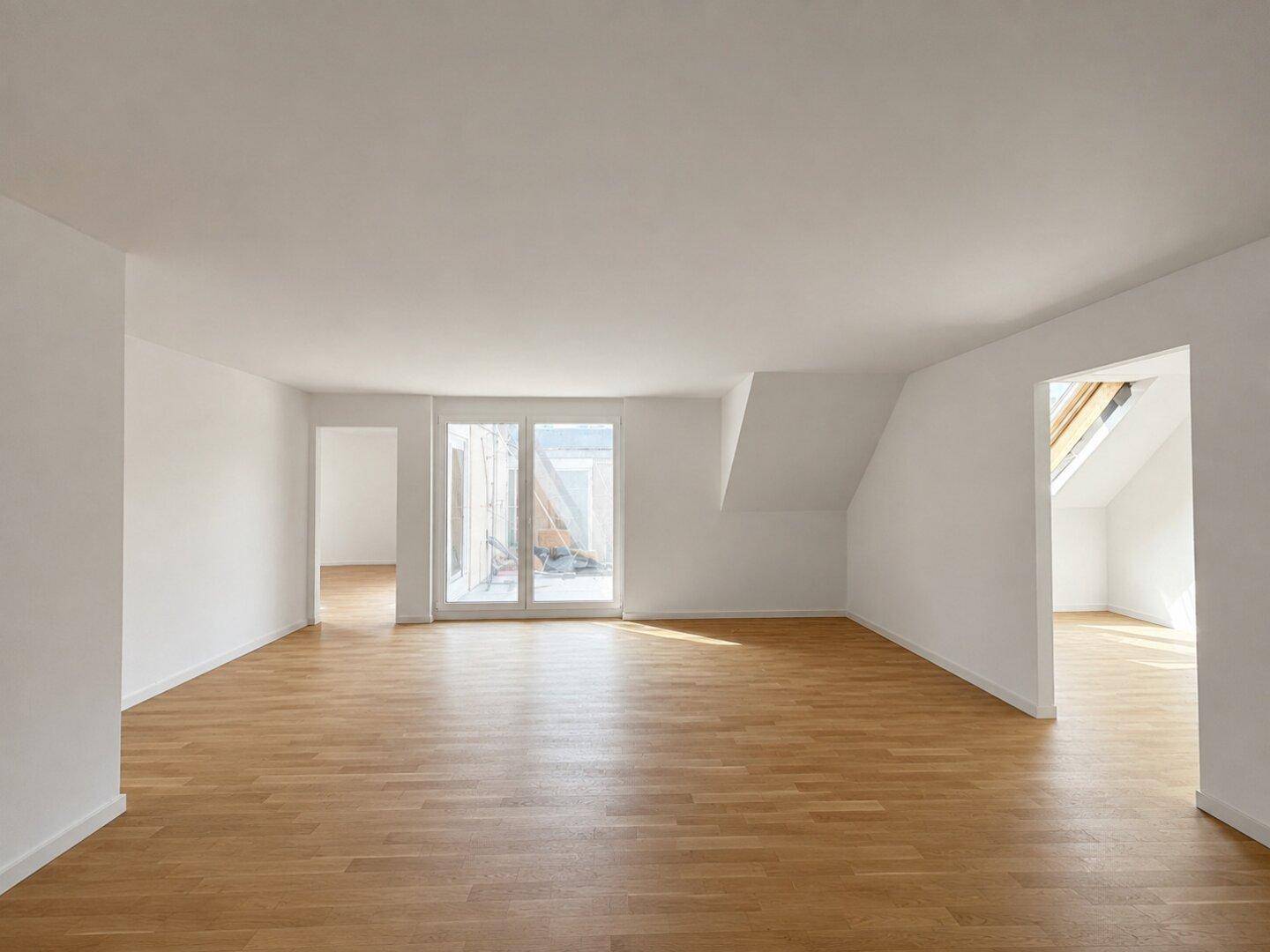 Leeres, lichtdurchflutetes Wohnzimmer mit Eichenparkett, weißen Wänden und Terrassenzugang.