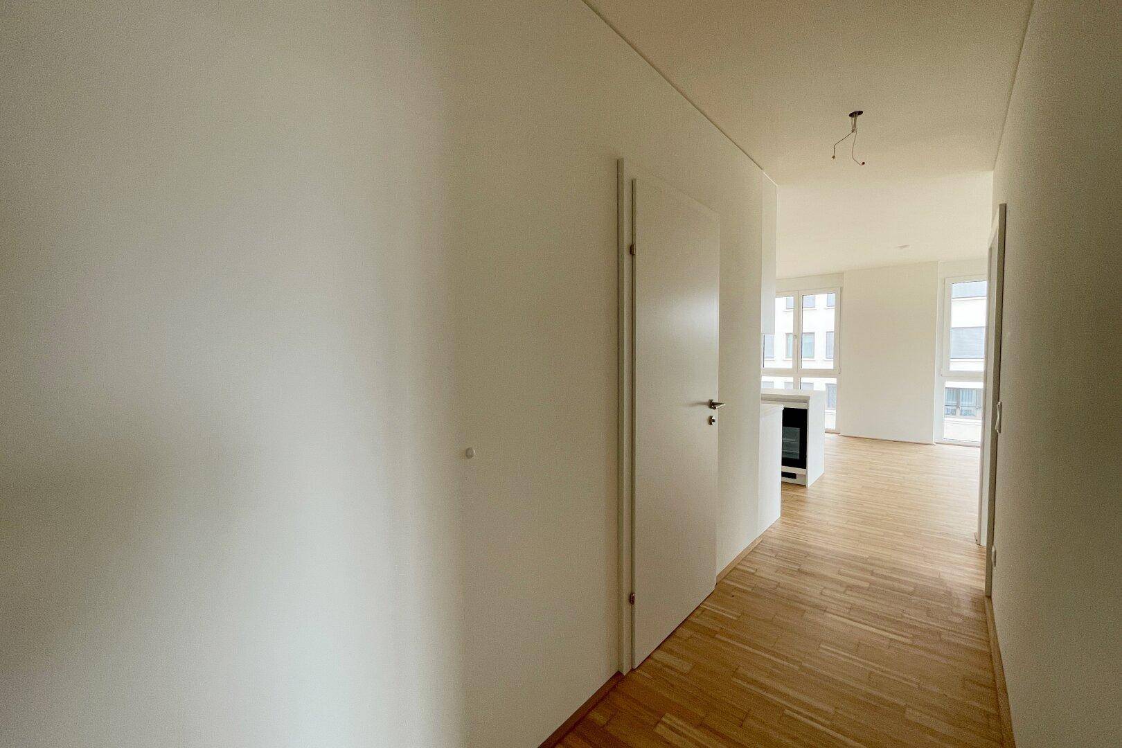Heller Flur mit Parkettboden, der zu den Wohnbereichen der Wohnung führt.