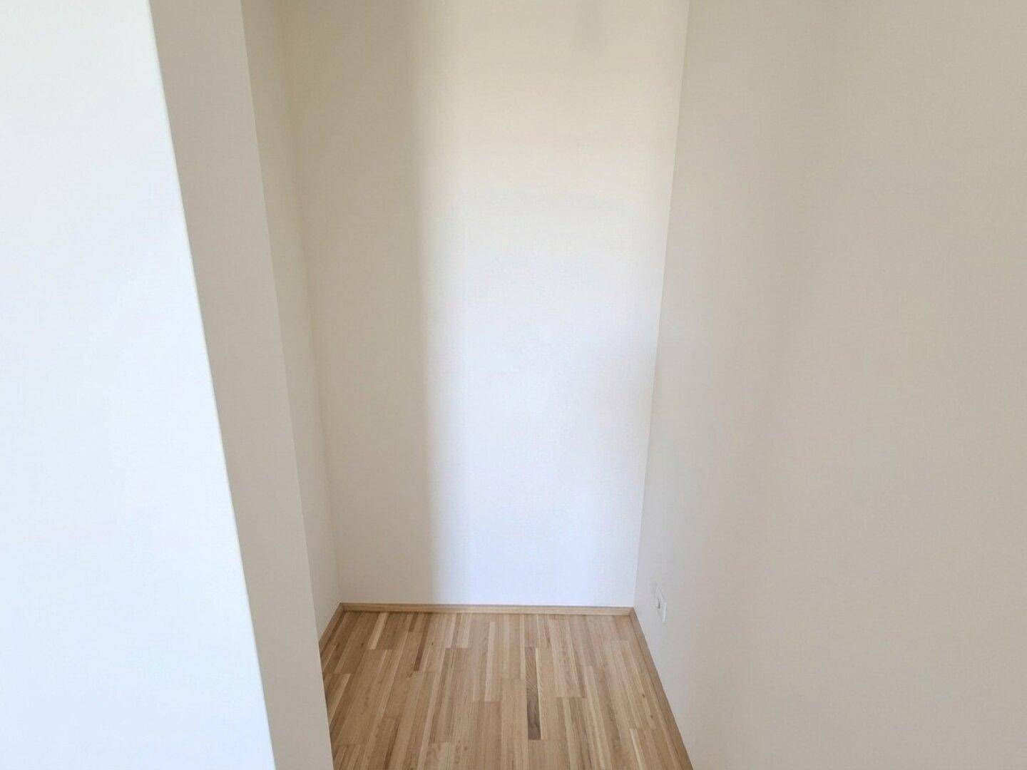 Kleiner, leerer Abstellraum mit Parkettboden, ideal für zusätzlichen Stauraum im Apartment.