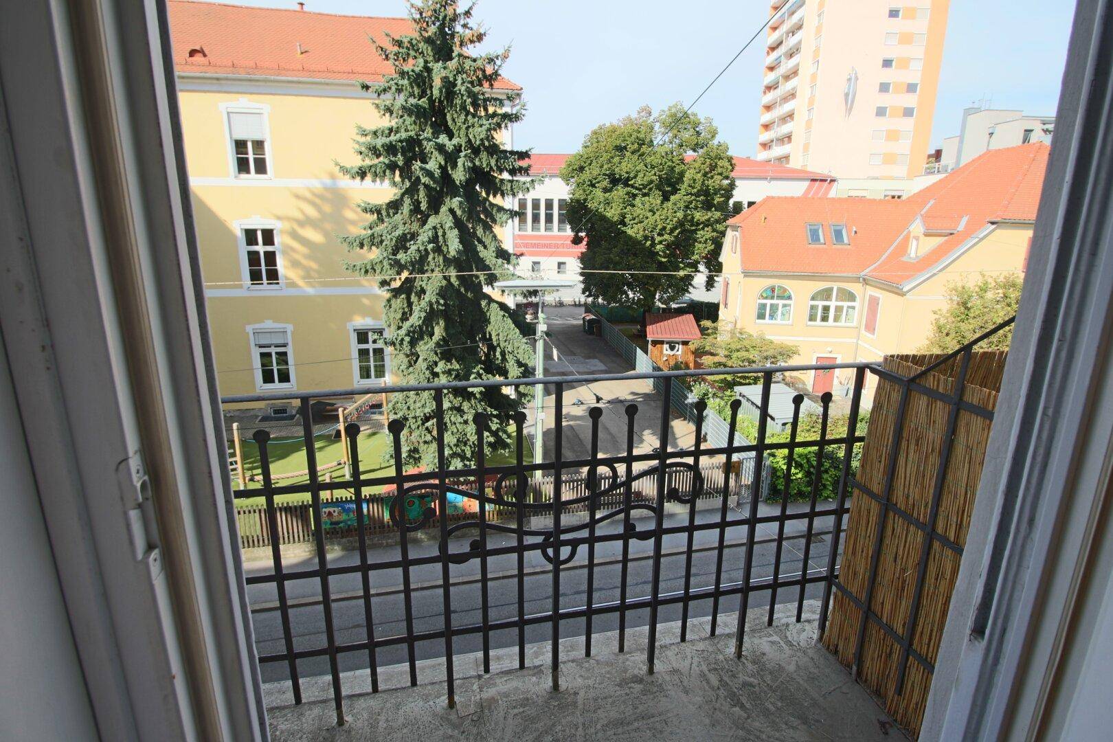 Blick vom Balkon auf die umliegende Nachbarschaft und einen Spielplatz.